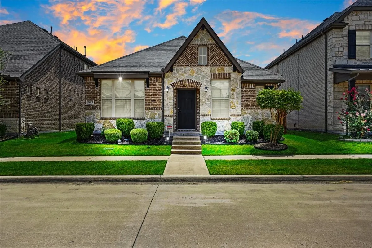 Front entrance with an arched brick detail, and a concrete walkway
