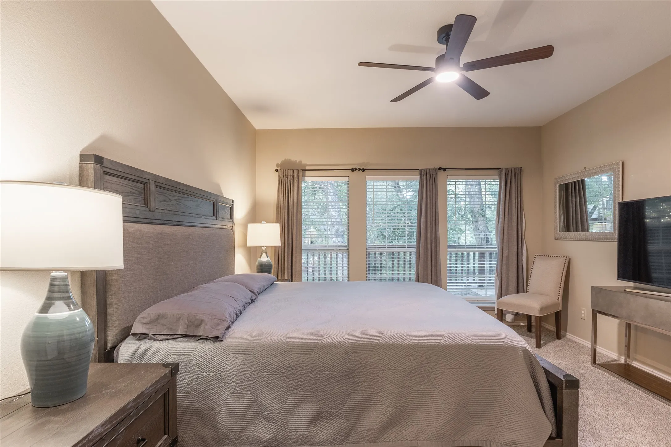 Dual windows with blinds and drapery, ceiling fan with integrated lighting, recessed lighting, and carpeted flooring