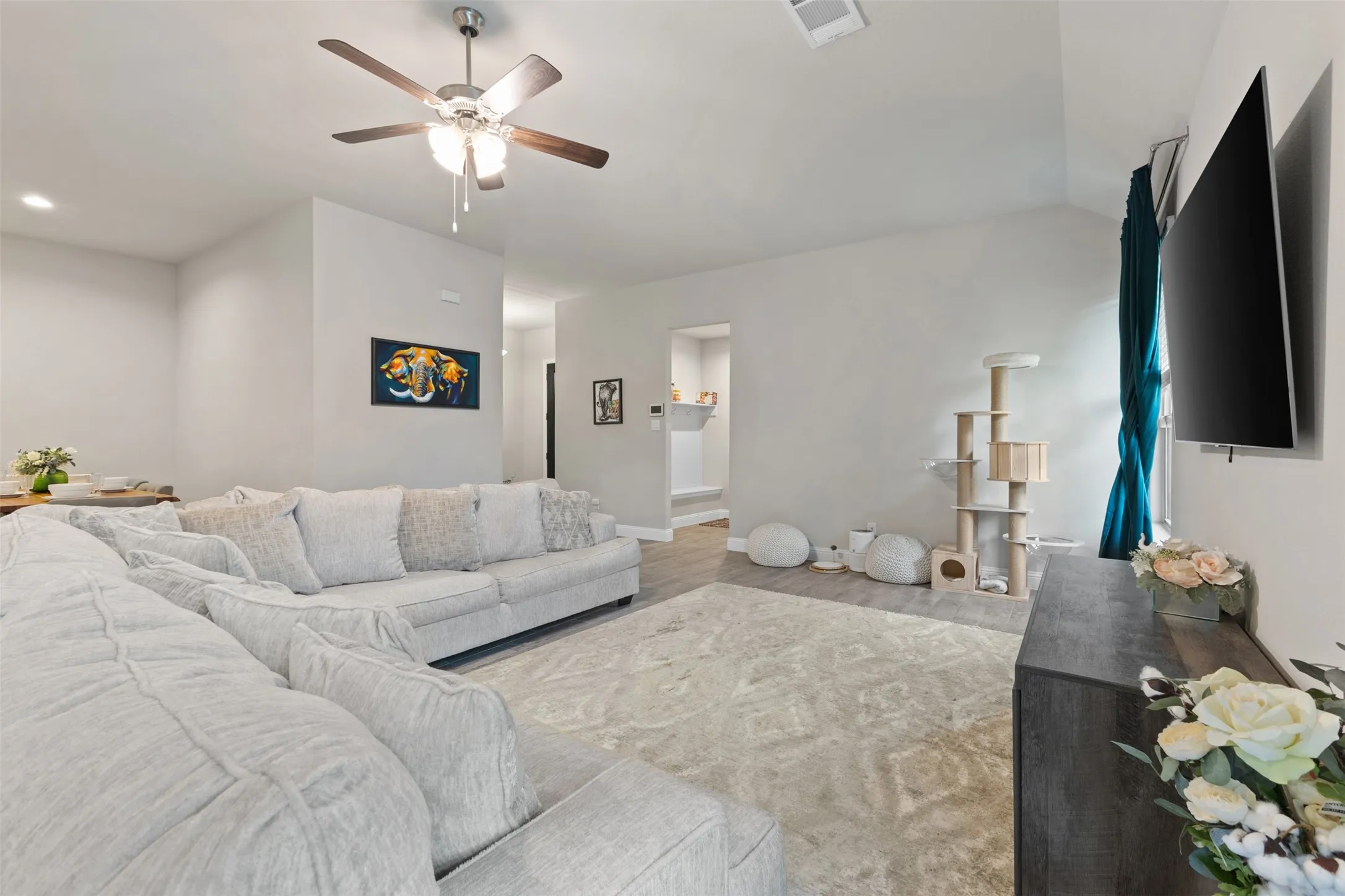Vaulted ceiling with a ceiling fan, light gray wall paint, wood-finish flooring, and recessed lighting
