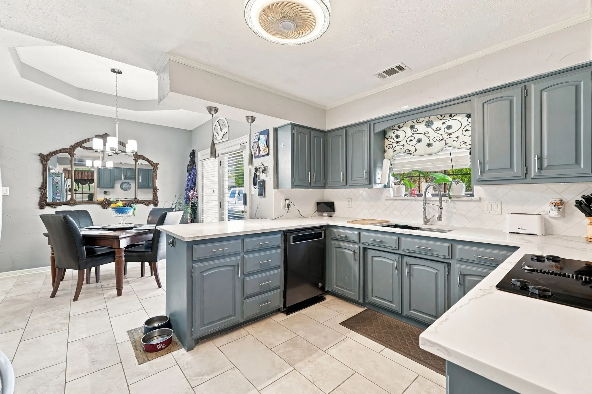 Kitchen featuring gray cabinetry, white countertops, a tile backsplash, and tile flooring