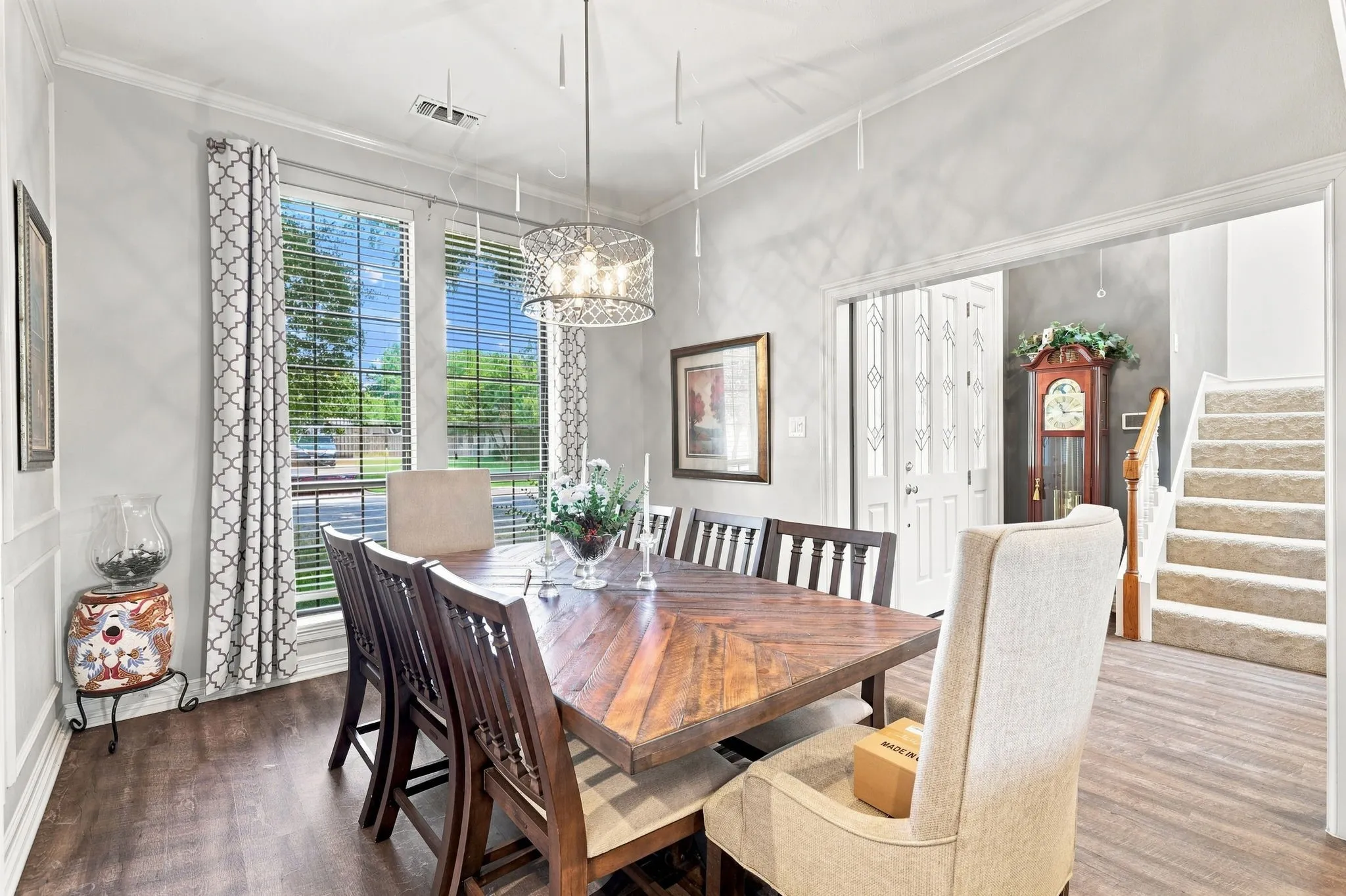 Wood-finish flooring throughout, bright window with blinds, and decorative light fixture