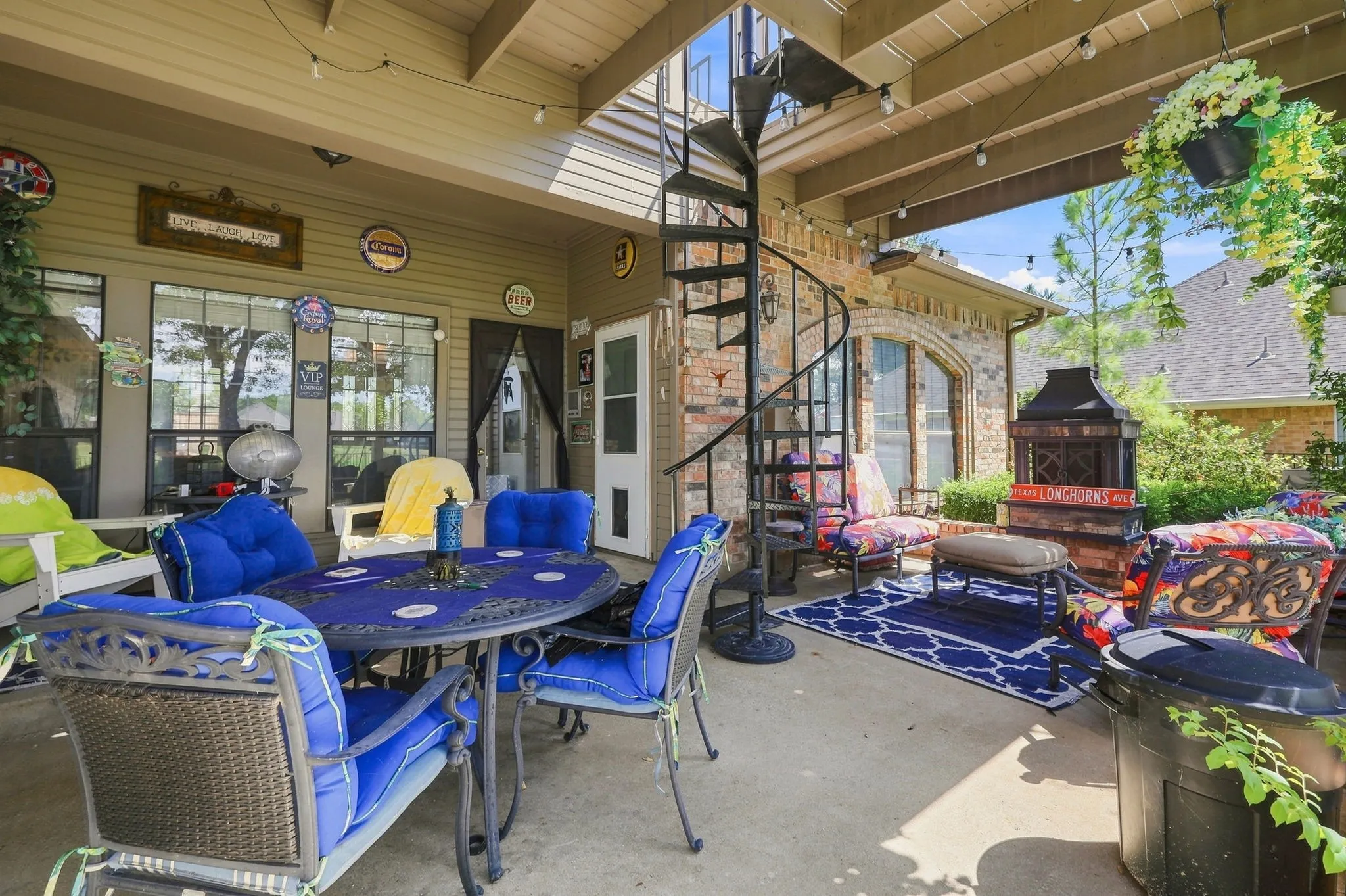Covered patio featuring a spiral staircase, exposed ceiling beams, and string lighting