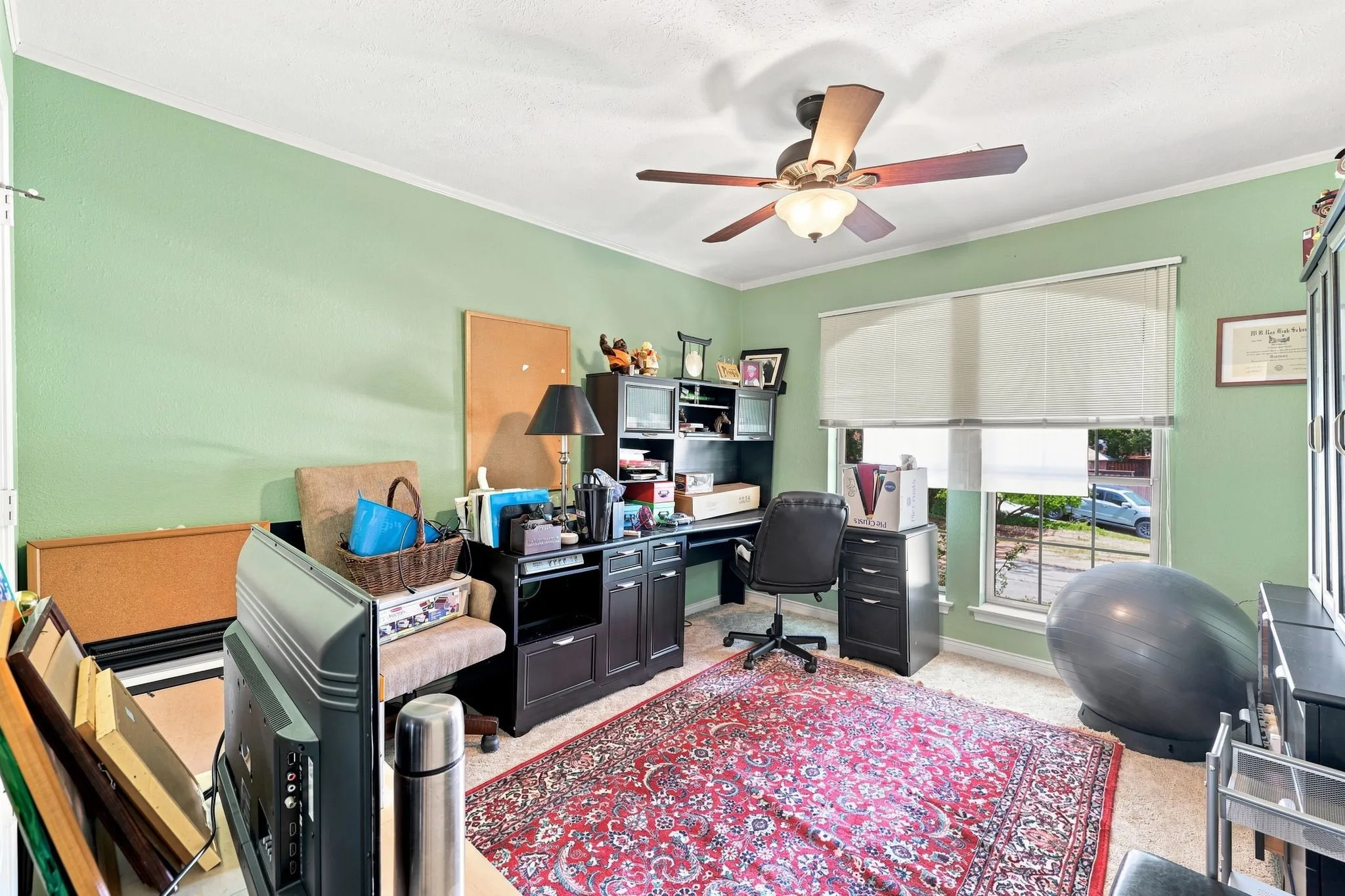 Room featuring a ceiling fan with integrated lighting, a window with blinds, and light green wall finishes