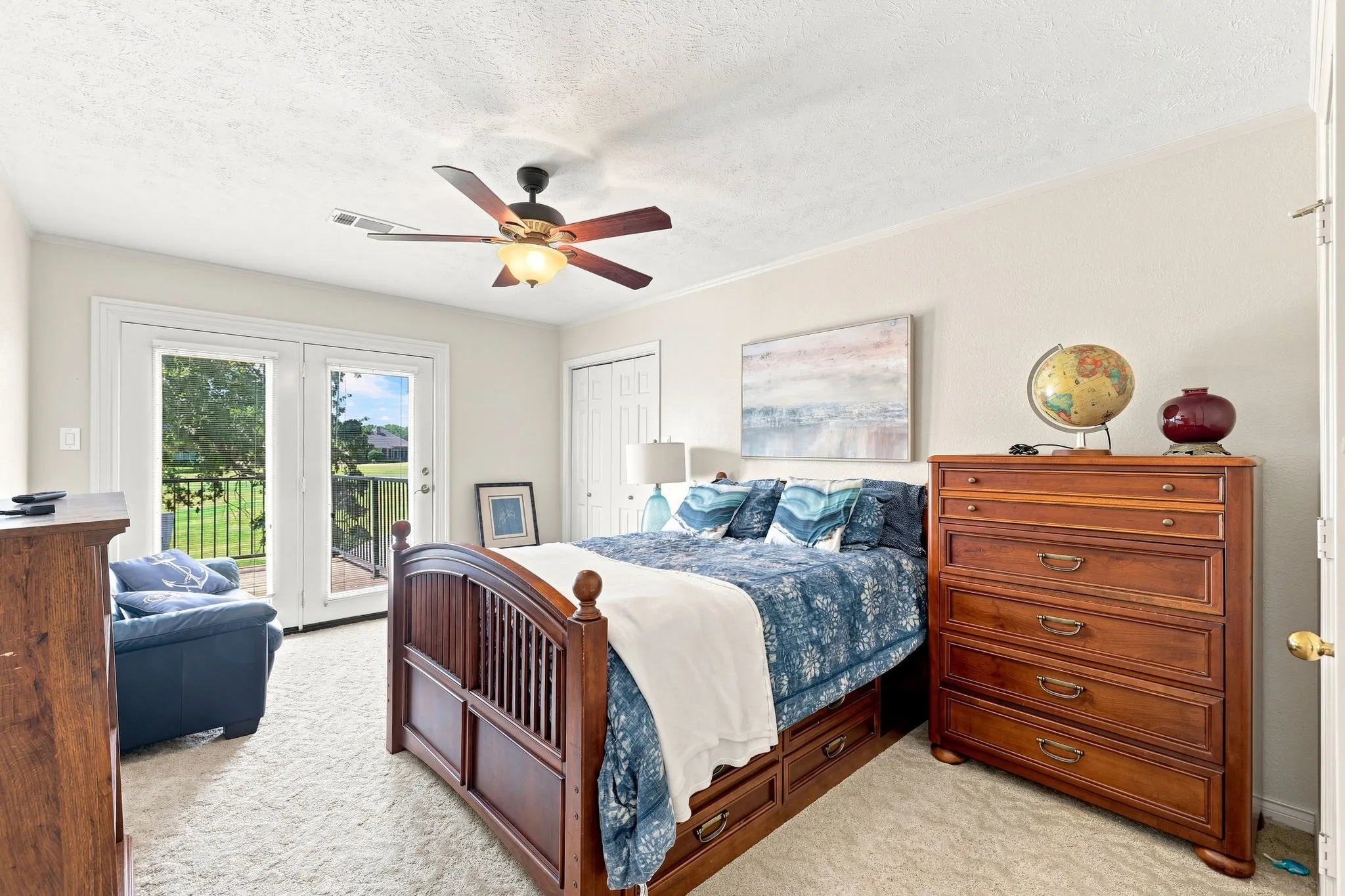 Dual French doors with exterior access, ceiling fan with integrated lighting, and carpet flooring