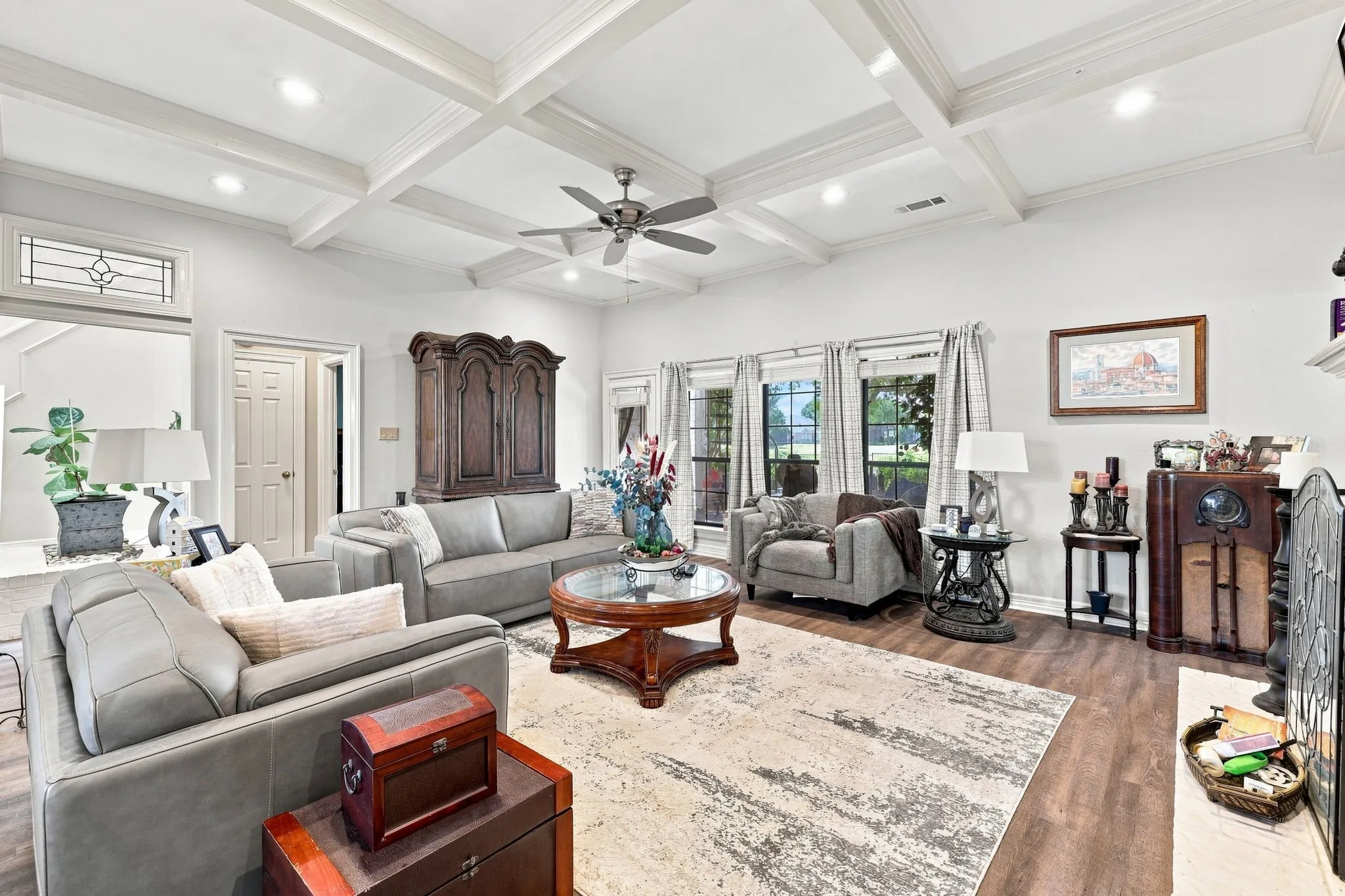 Coffered ceilings, recessed lighting, wood-finish flooring, ceiling fan, and multiple large windows