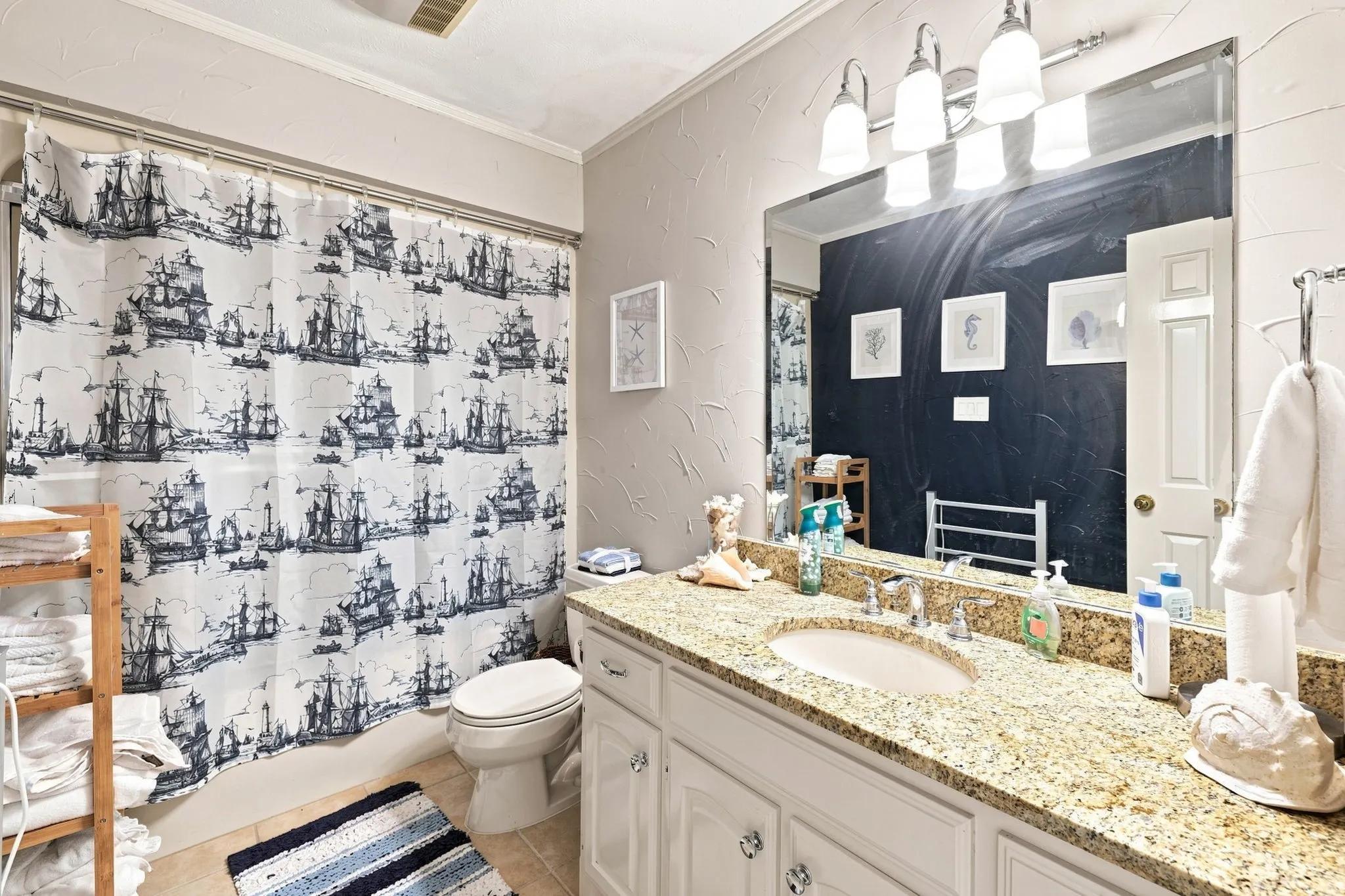 Bathroom featuring a vanity with an integrated sink, a speckled countertop, and white cabinetry
