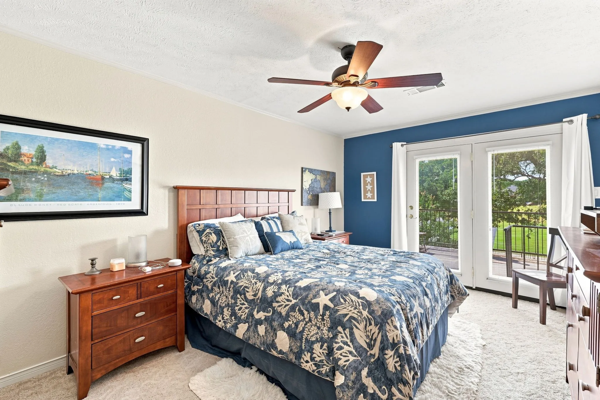 Dual French doors with exterior access, ceiling fan with integrated lighting, two-tone wall finishes, and carpeted flooring