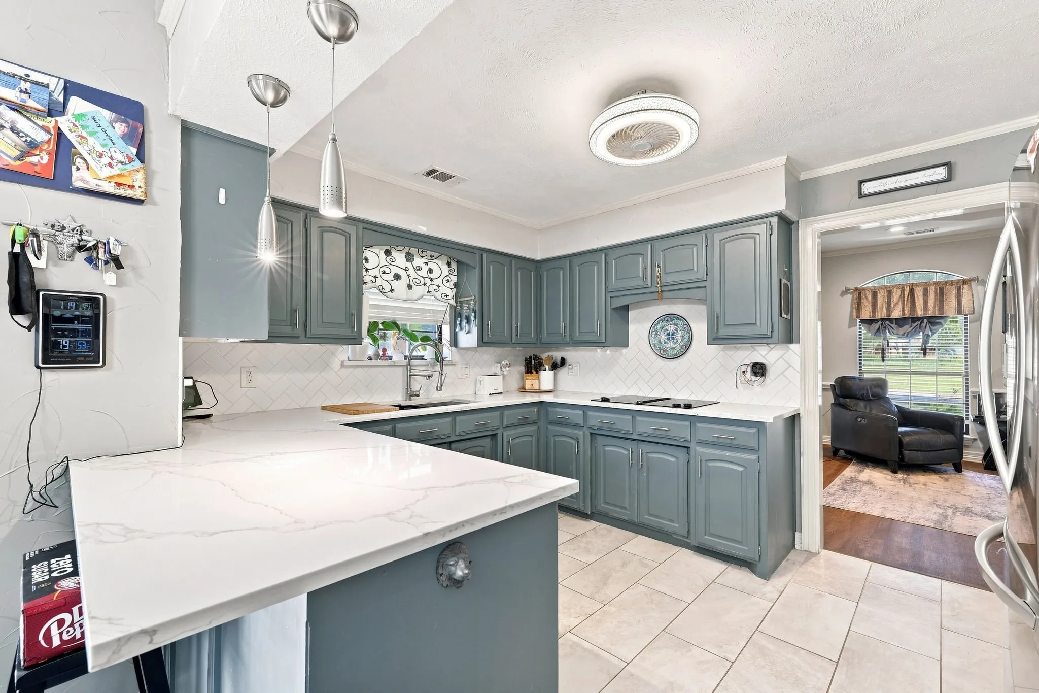 Kitchen featuring blue cabinetry, white countertops, subway tile backsplash, and tile flooring