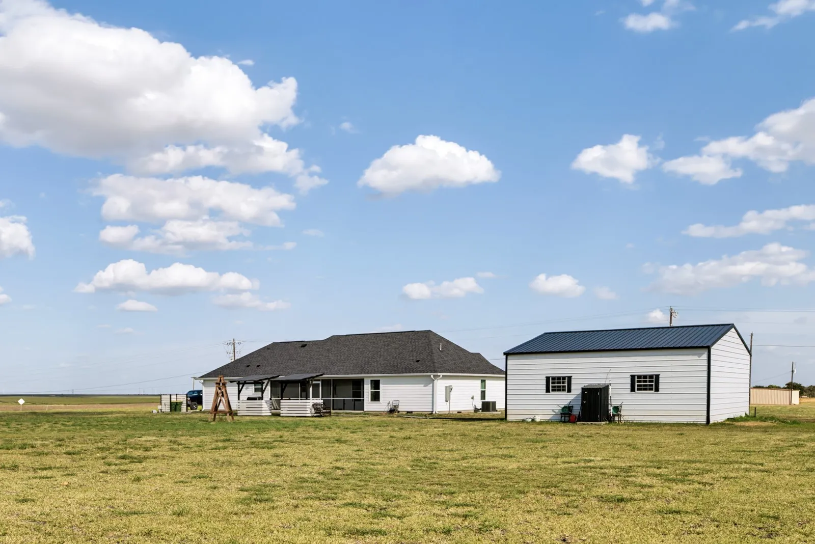 Single-story residence with a covered patio and an auxiliary structure featuring a metal roof