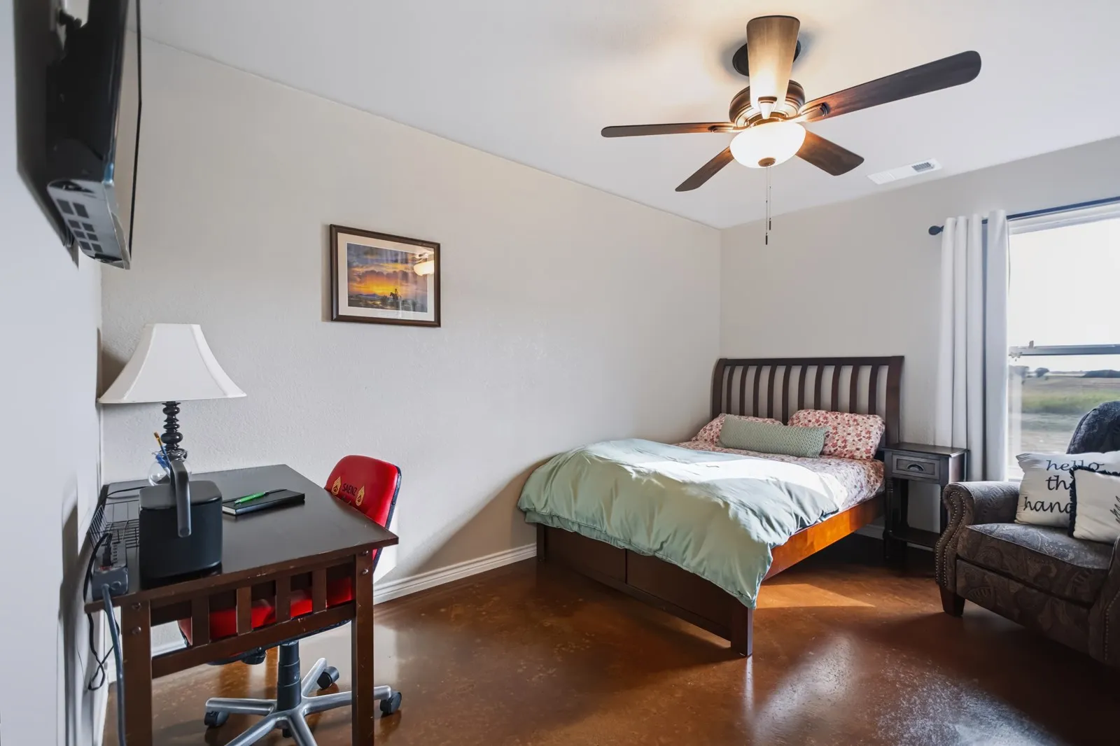 Guest Room 2
Smooth finished flooring, wall-mounted television, ceiling fan with integrated lighting, wood-frame bed with slatted headboard, and window with curtains