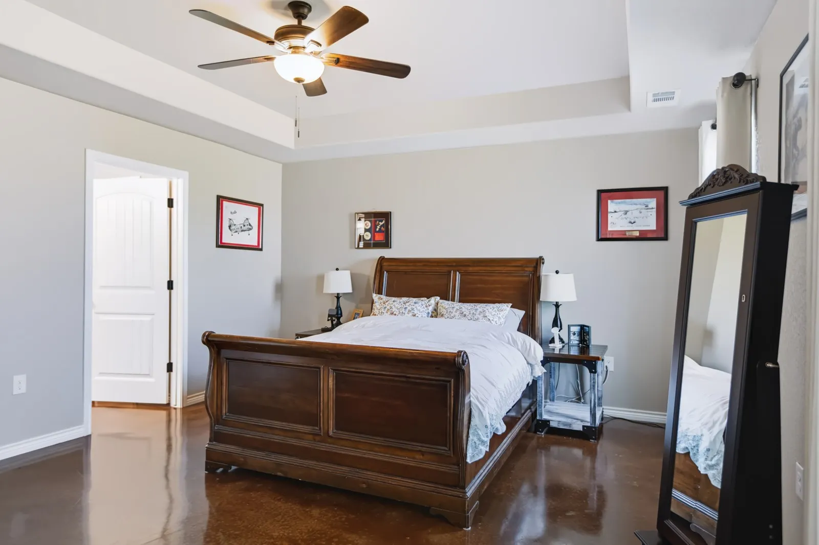 
Tray ceiling with a ceiling fan, wood-finish flooring, and white paneled interior doors