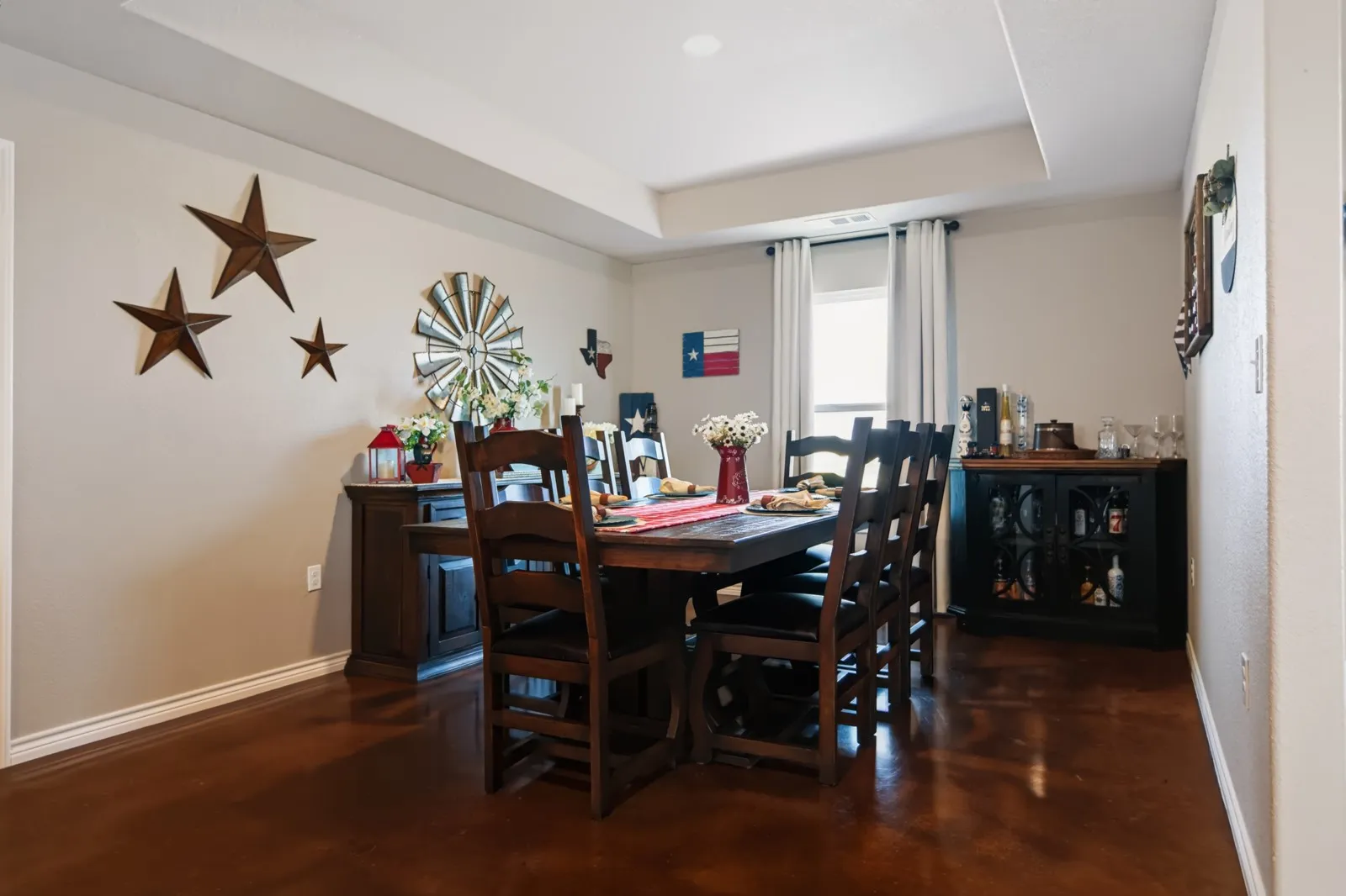 Recessed lighting, tray ceiling, neutral wall color, and dark-toned flooring