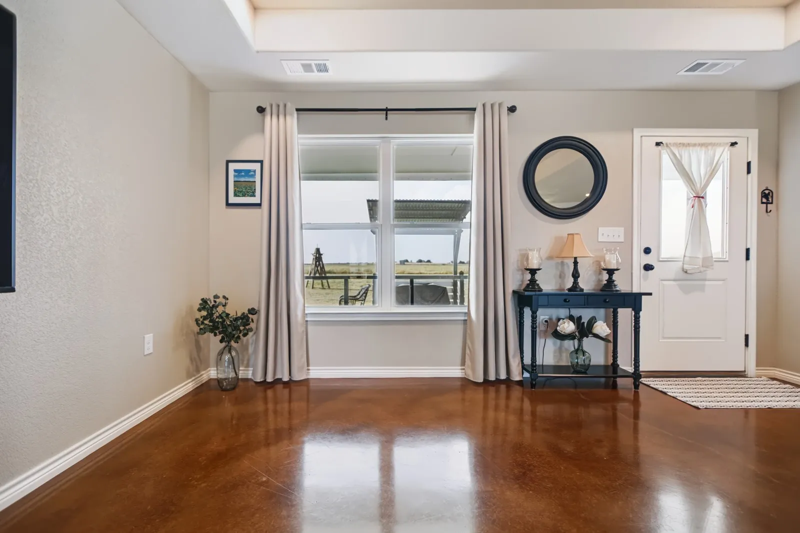Tray ceiling, wood-finish flooring, white window trim, white baseboards, and a white paneled door