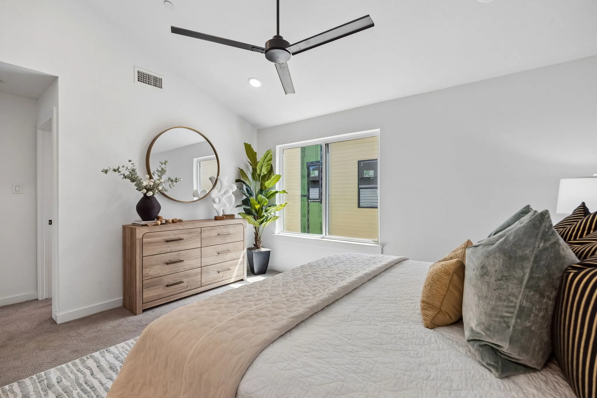 Vaulted ceiling with a contemporary ceiling fan, recessed lighting, and a large window