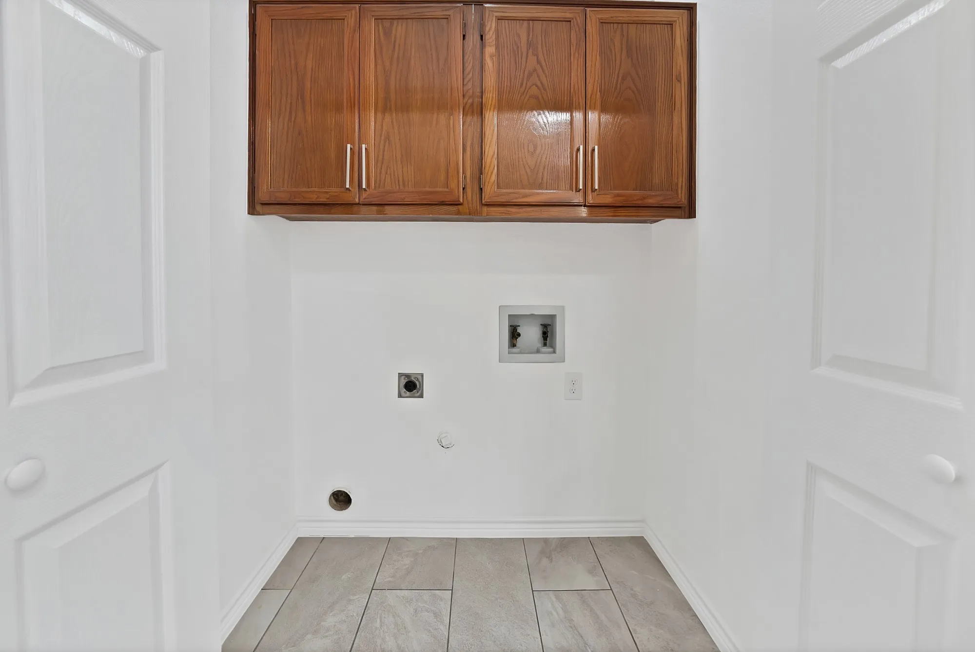 Built-in wood-finish cabinetry, tile flooring, and white paneled doors