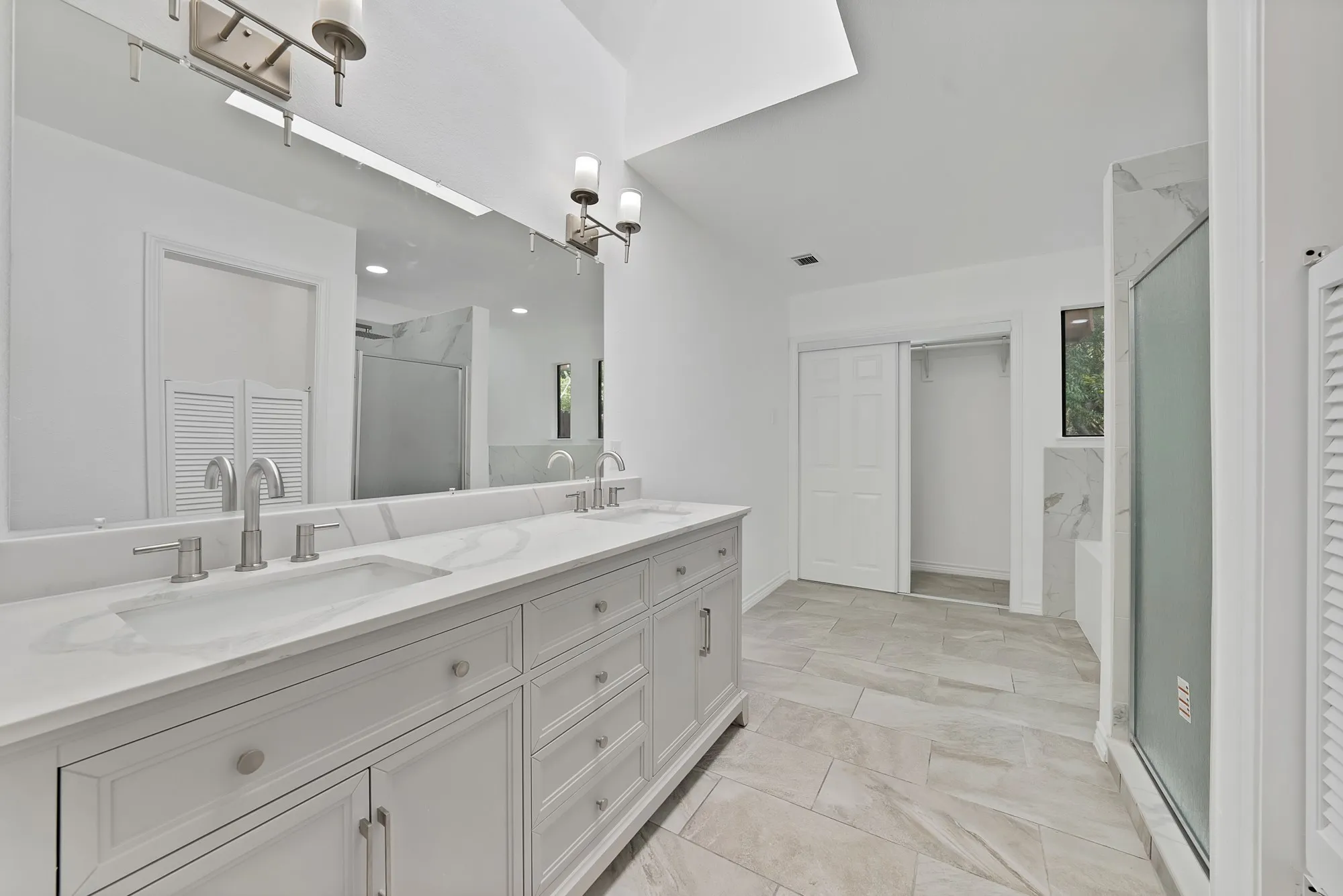 Dual vanity with undermount sinks, stone countertop, and brushed nickel fixtures