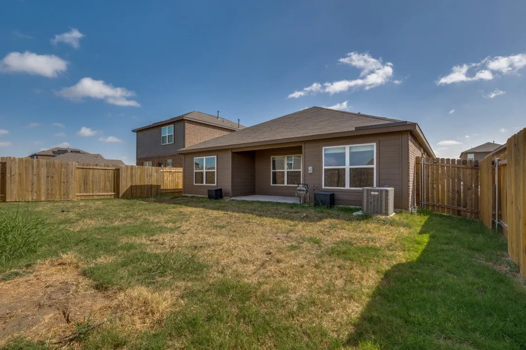 Spacious single-story residence with a taupe exterior and modern architectural lines, featuring a covered rear patio