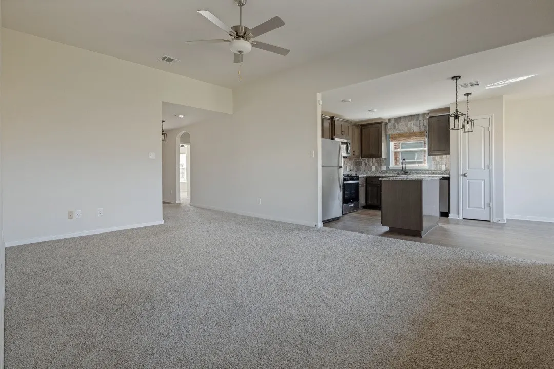 Kitchen featuring stainless steel appliances, dark wood-finish cabinetry, and a tile backsplash