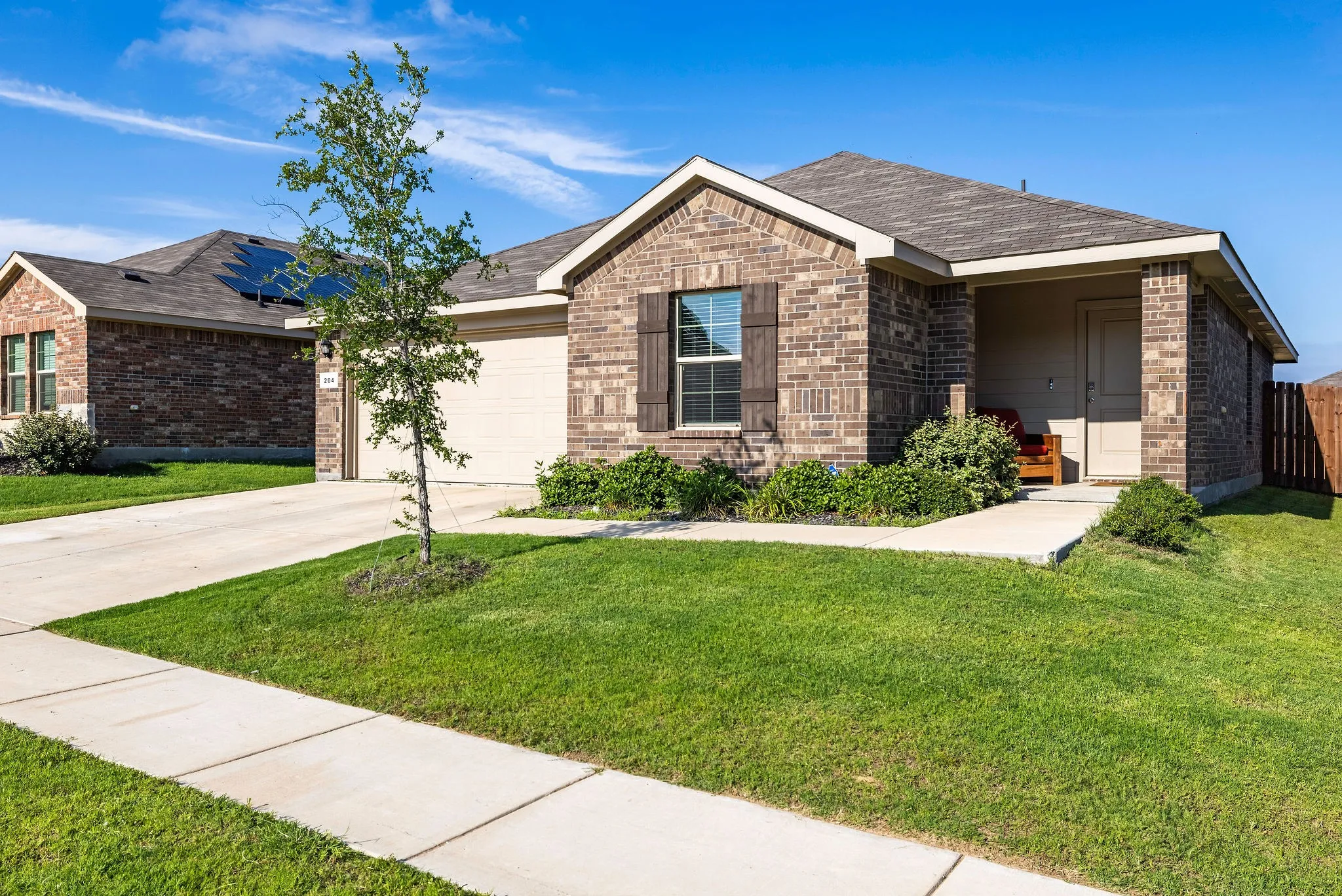 Ranch-style home with brick siding, a garage, concrete driveway, and roof with shingles