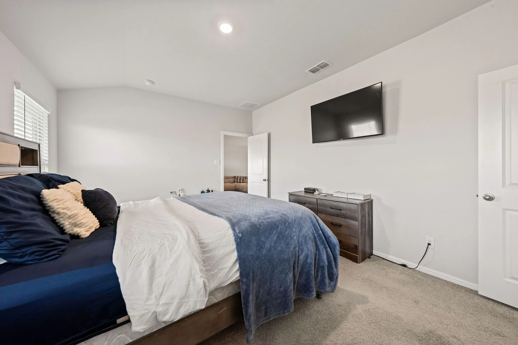 Carpeted bedroom featuring vaulted ceiling and baseboards