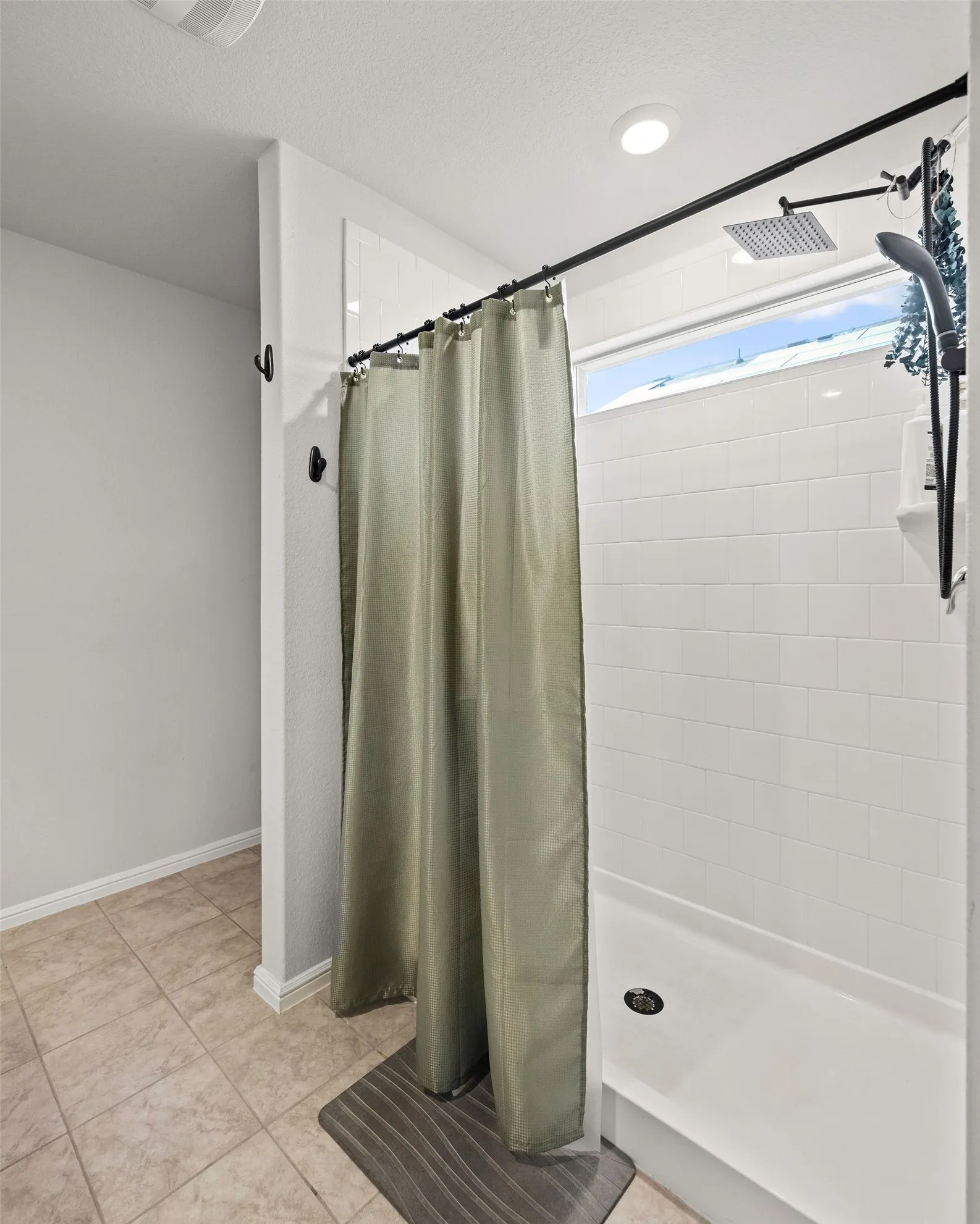 Bathroom featuring tiled shower and tile patterned floors