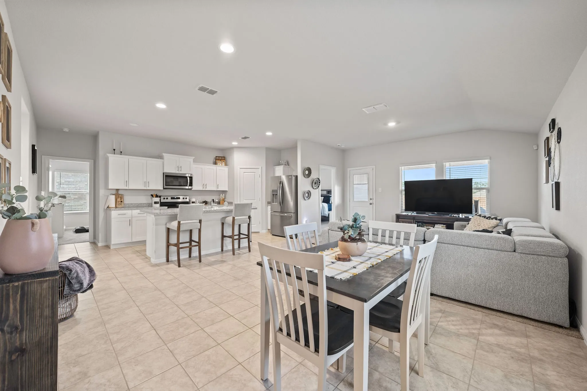 Dining space with plenty of natural light, light tile patterned floors, lofted ceiling, and recessed lighting