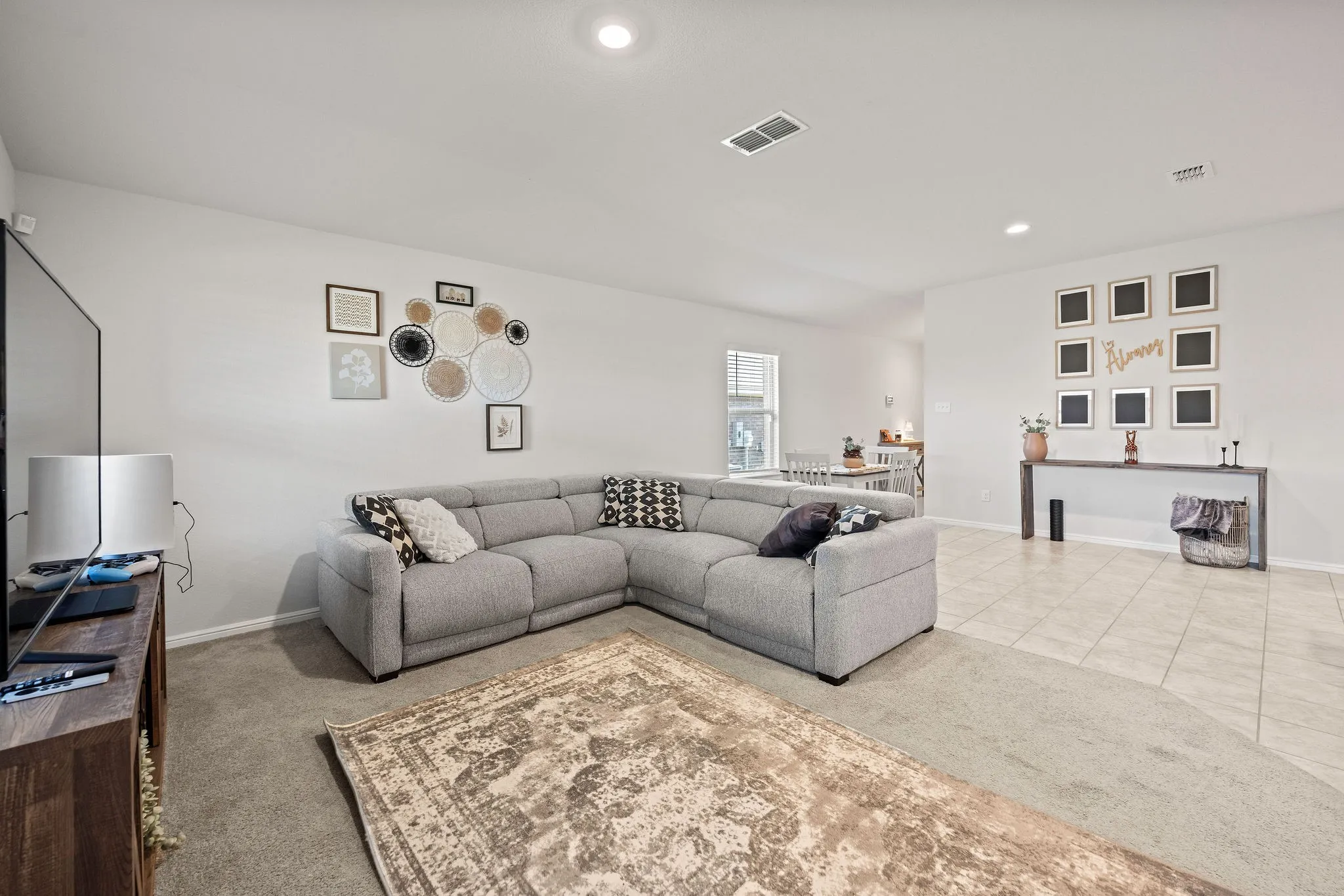 Living area with carpet, recessed lighting, and tile patterned floors