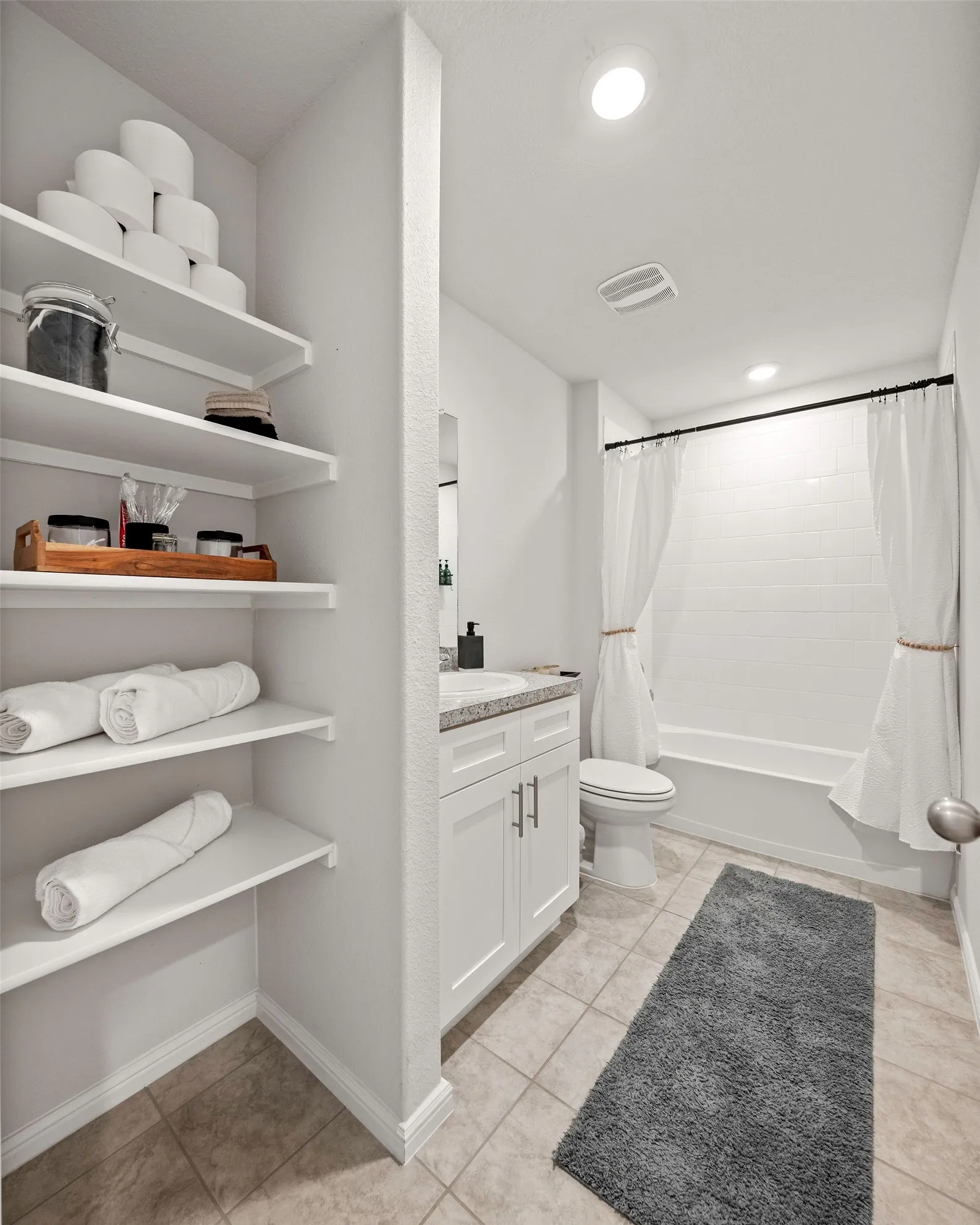 Full bathroom with vanity, shower / bath combo with shower curtain, and tile patterned flooring