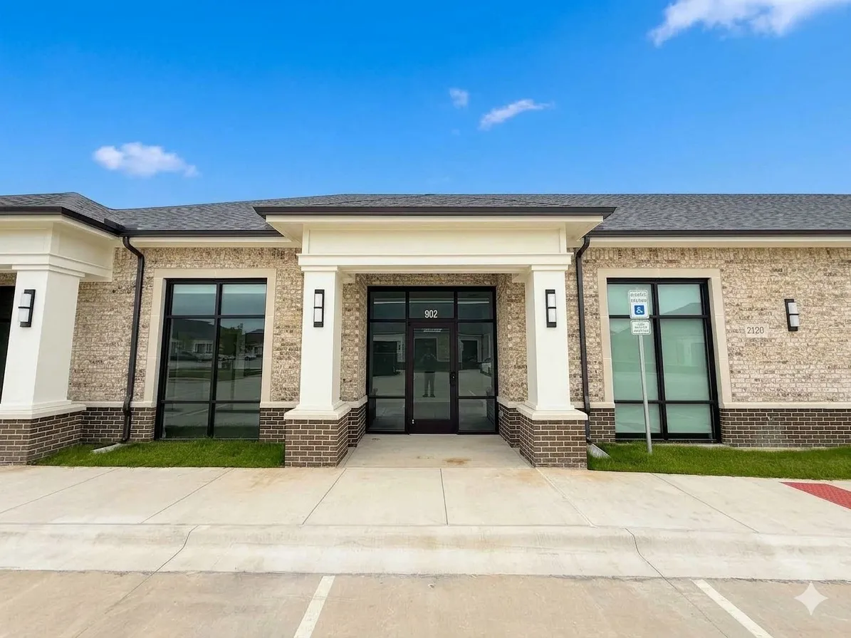 Brick facade with white column accents, expansive glass storefront, and a prominent entry
