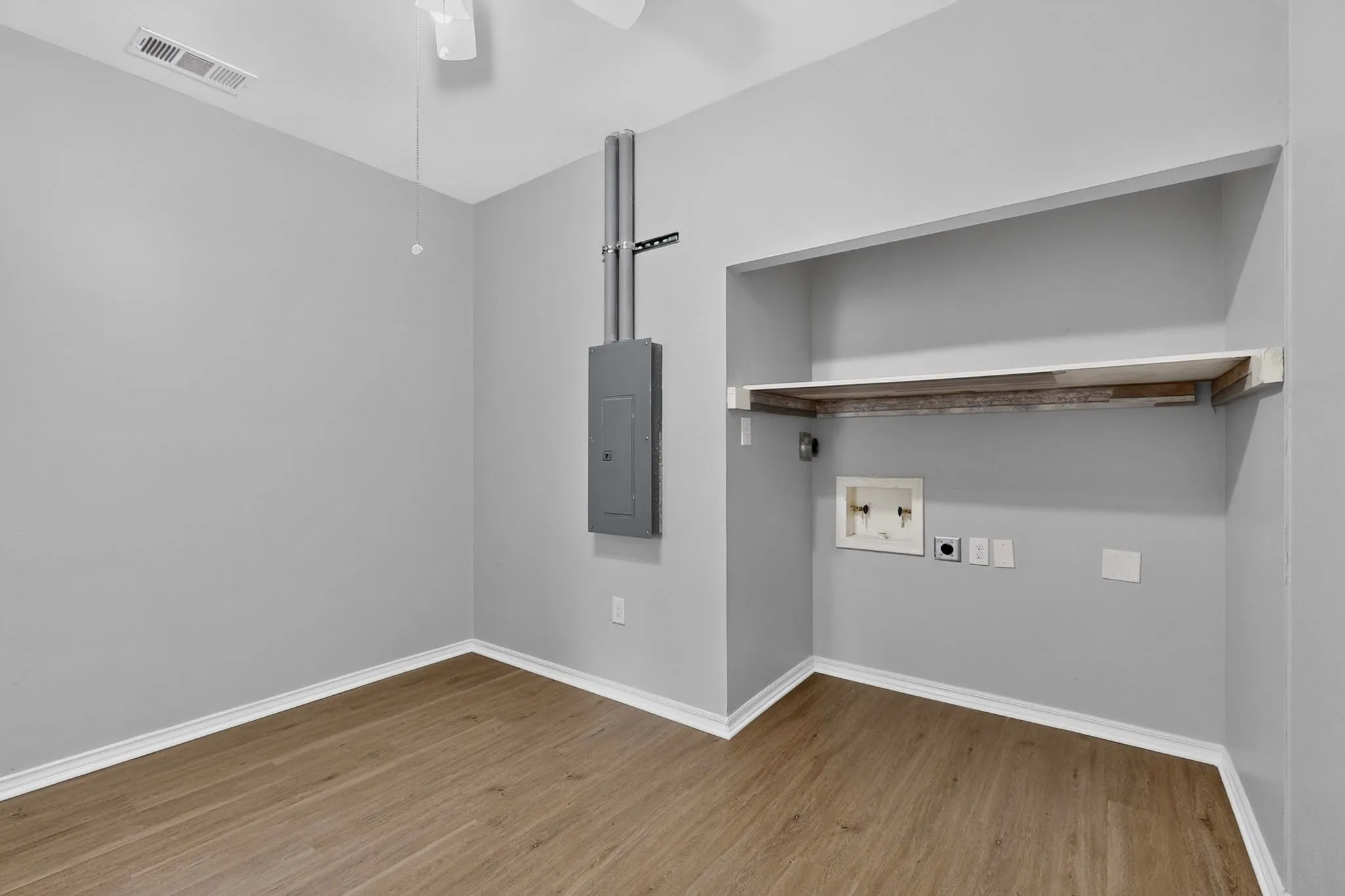 Neutral painted walls, wood-finish flooring, and built-in shelving