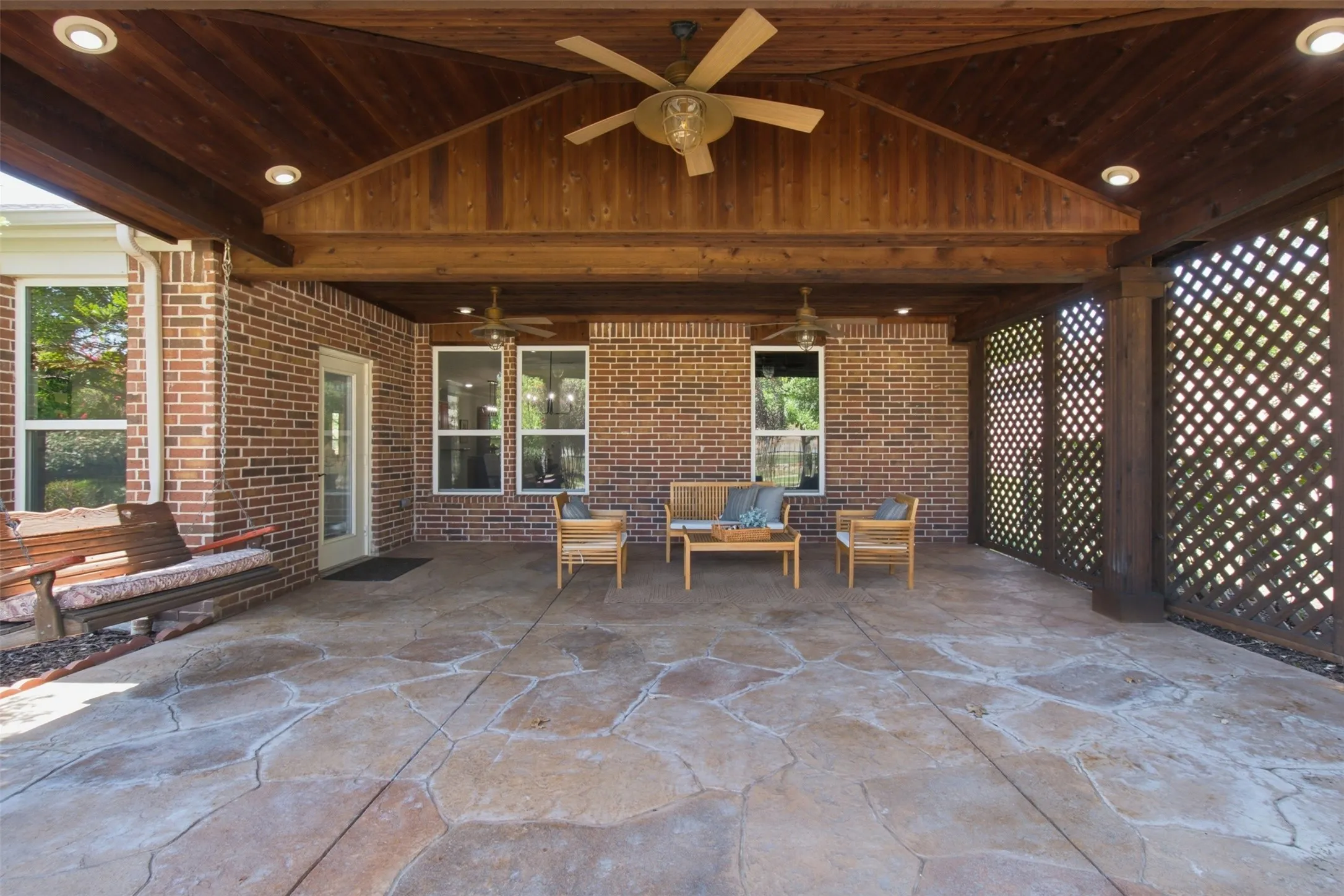 Huge extended patio with recessed lighting and multiple fans