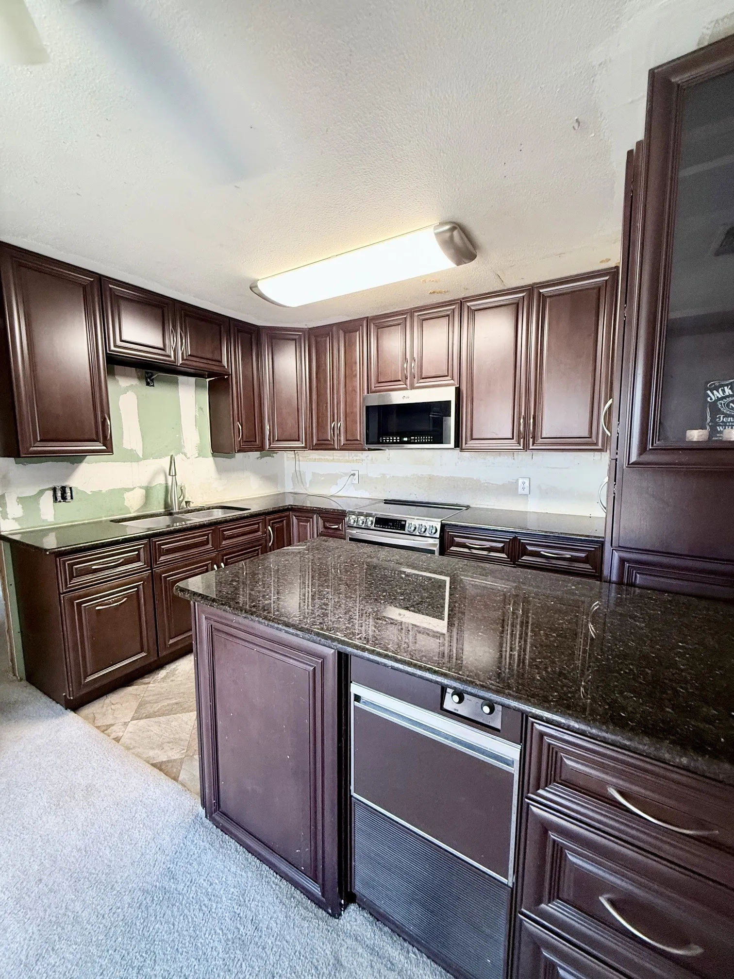 Kitchen featuring dark wood-finish cabinetry, dark countertops, and a built-in microwave