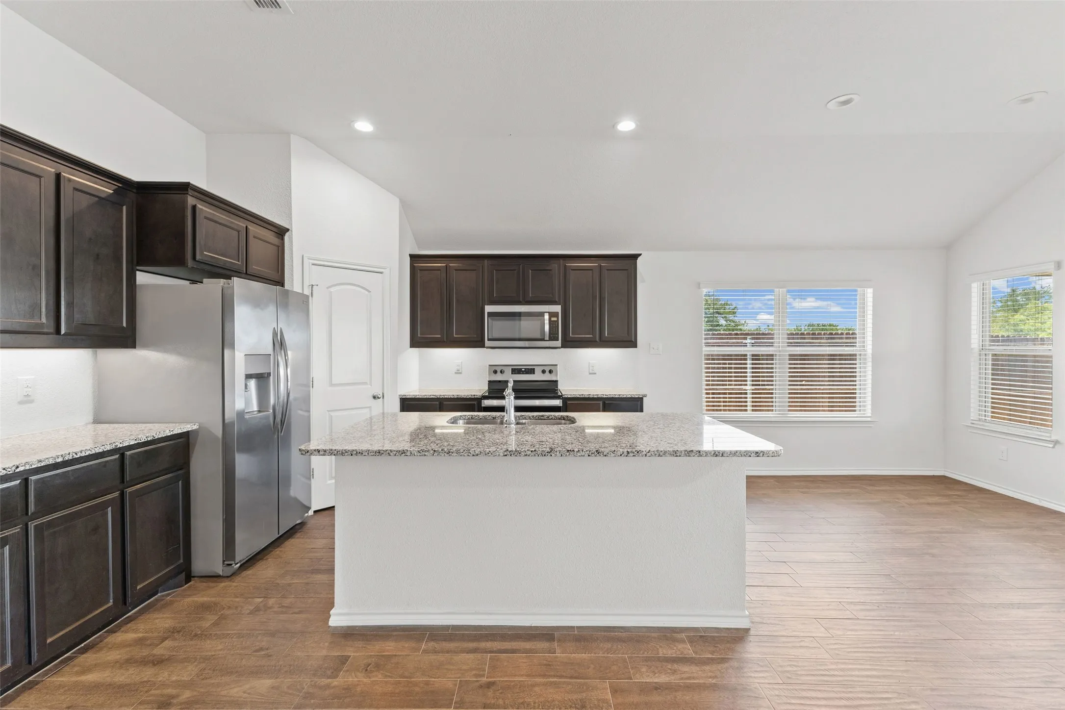 Large kitchen with island, stainless appliances and granite counters