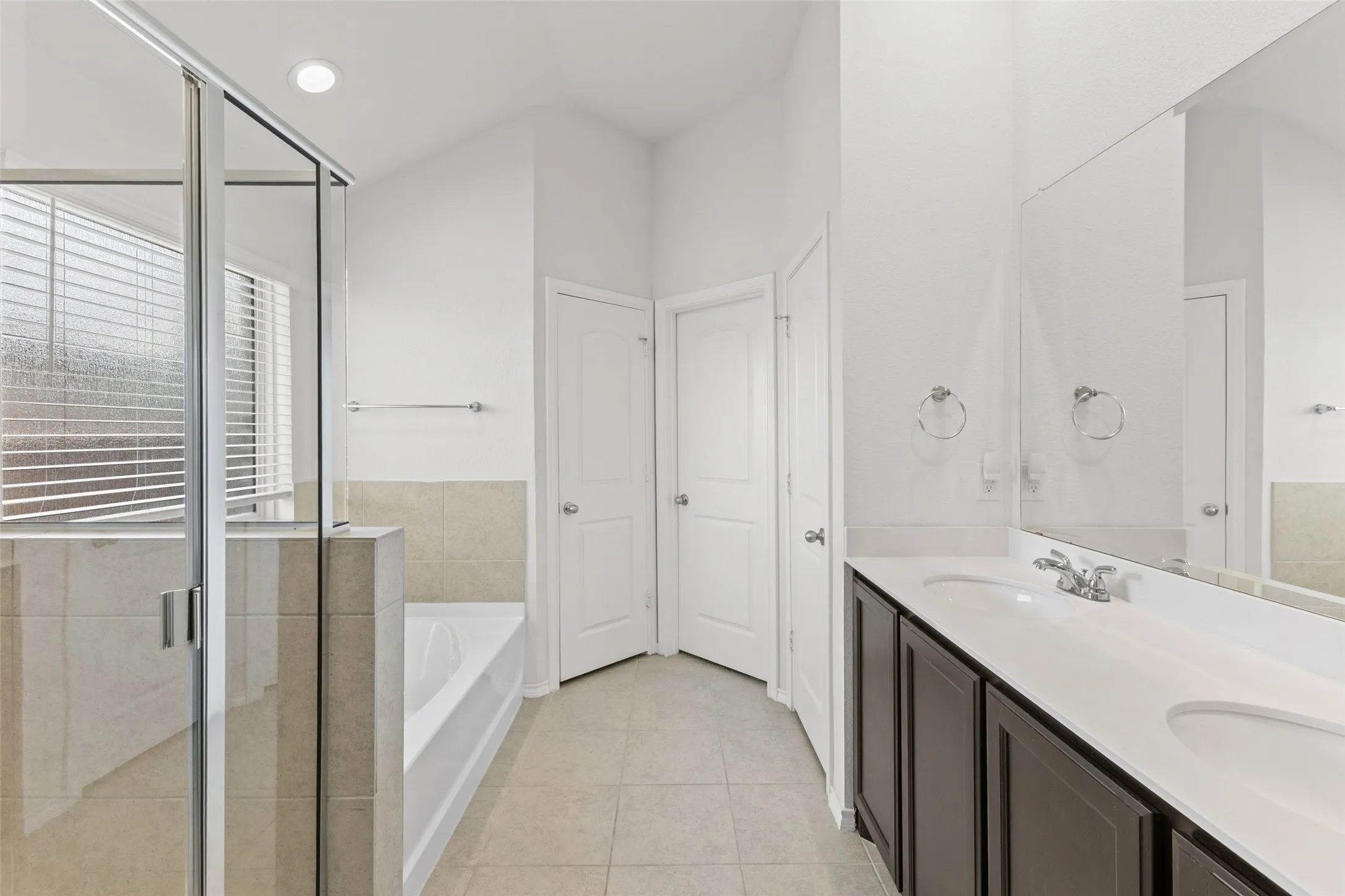 Primary bathroom has double sinks, separate shower and tub, plus a linen closet