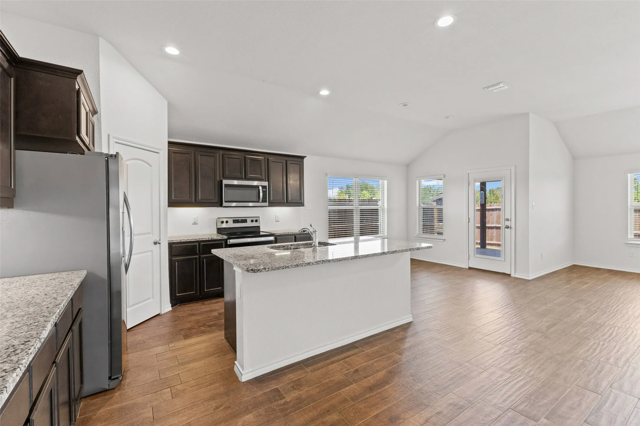 Large kitchen with island, stainless appliances and granite counters