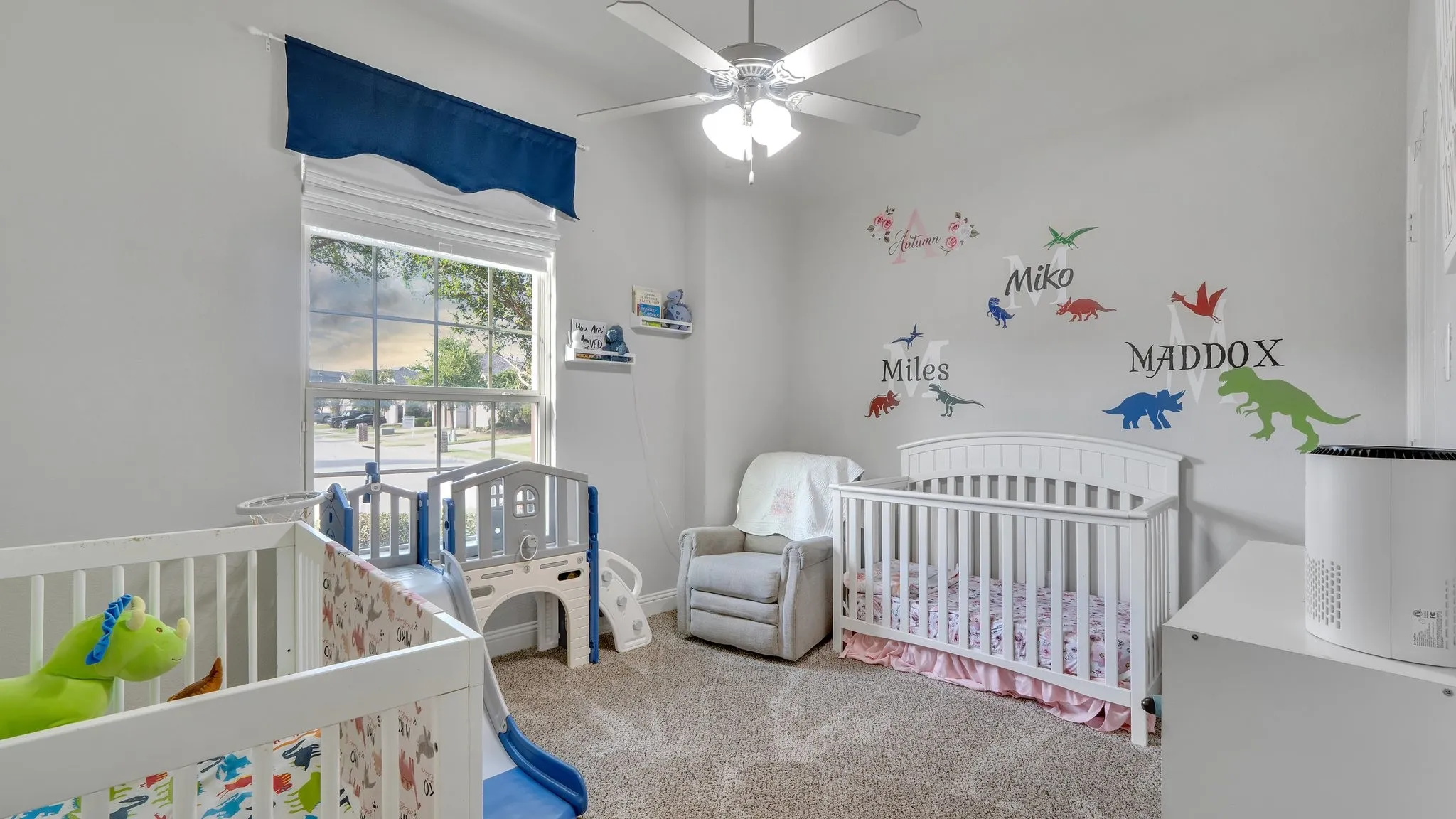 Bright secondary bedroom with plush carpet, ceiling fan, and natural light.