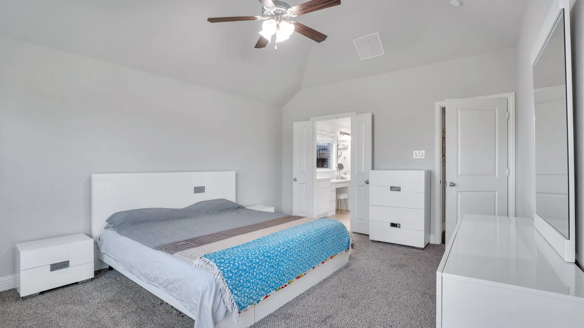 Plush carpet flooring, vaulted ceiling, and an attached ceiling fan with integrated lighting