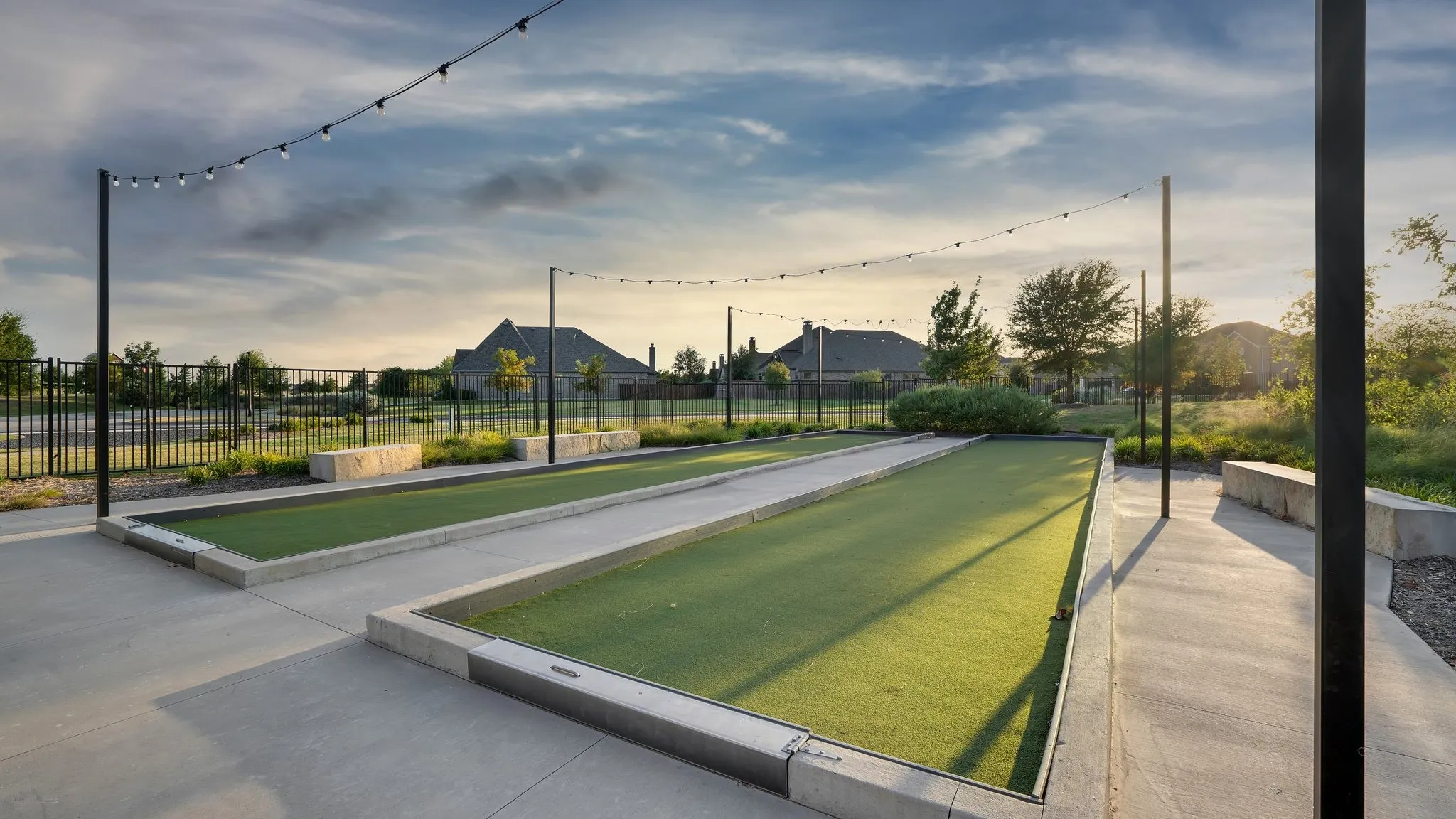 Dual bocce ball courts featuring artificial turf surfaces and concrete borders