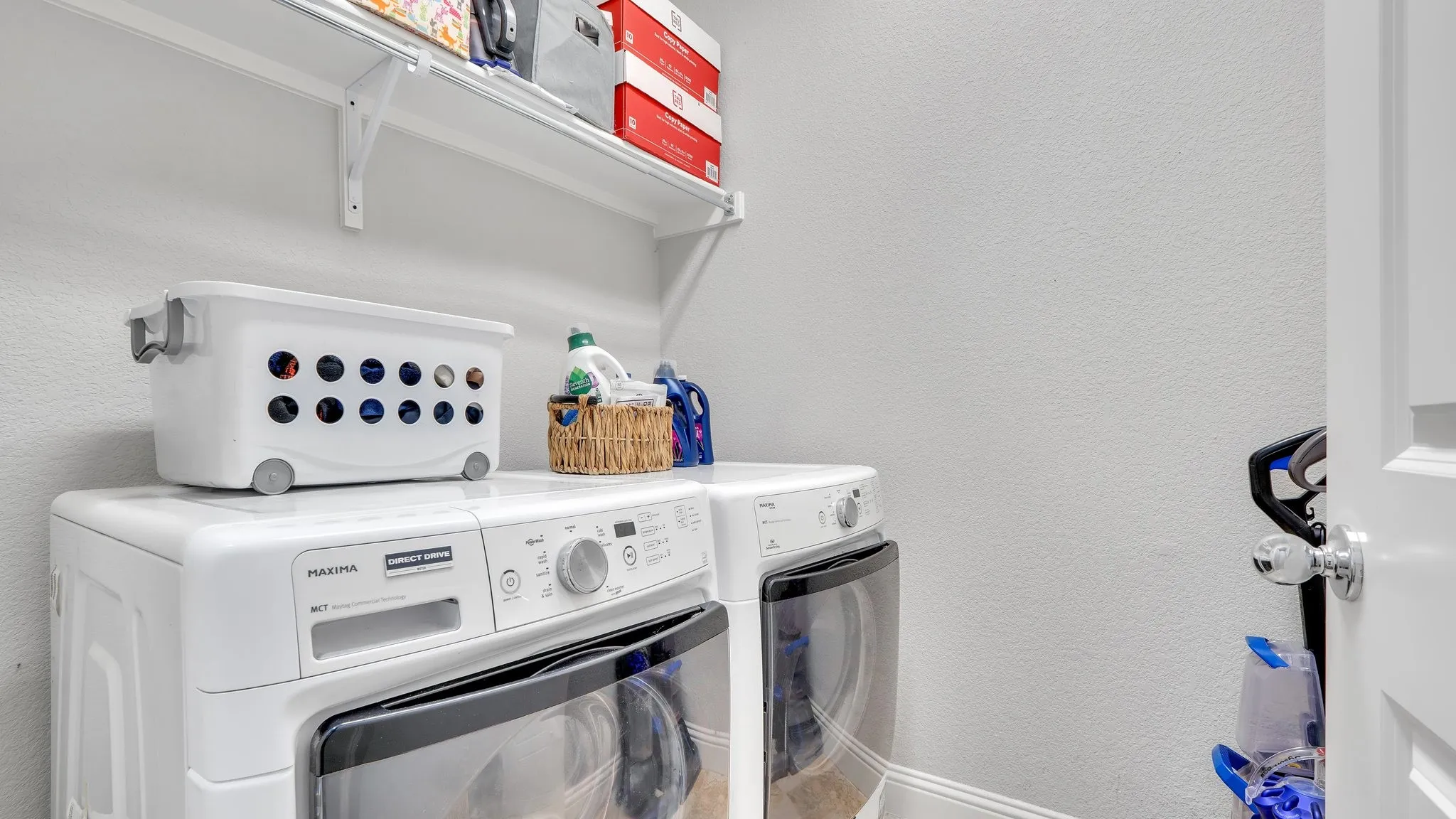Laundry area featuring a built-in shelf and light-toned walls