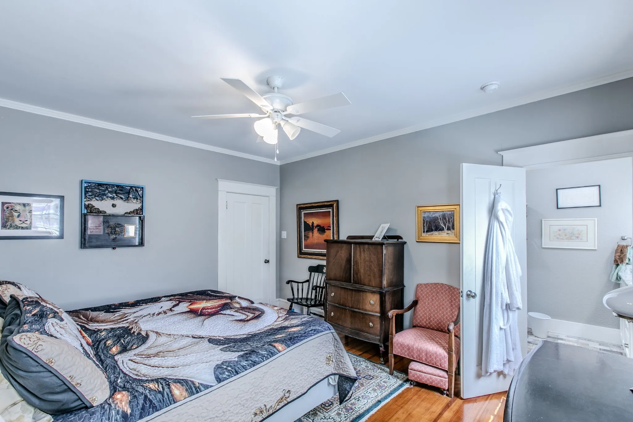 Hardwood flooring, crown molding, ceiling fan with integrated lighting, and white trim