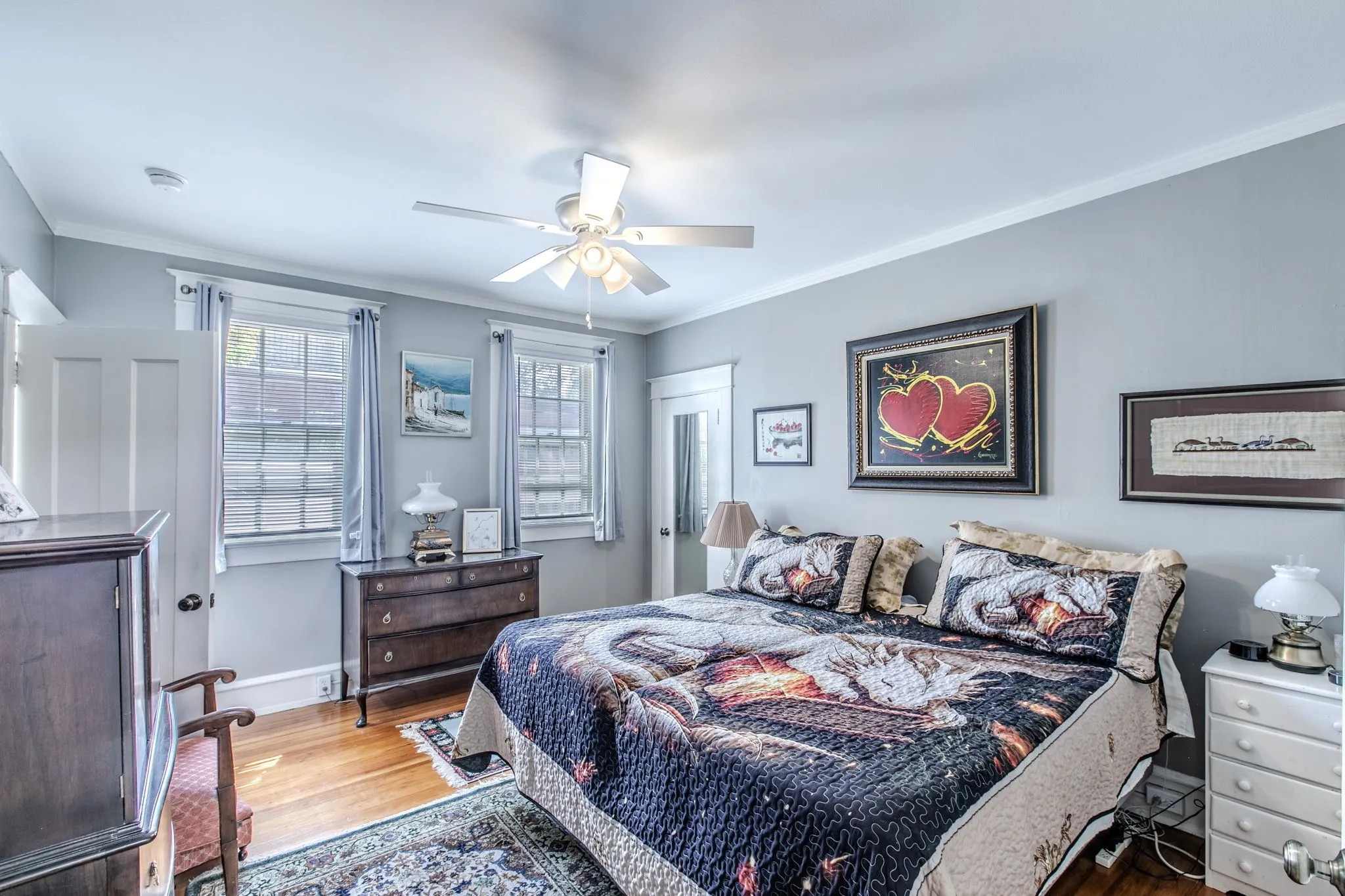 Hardwood flooring, painted walls, ceiling fan, crown molding, and multiple windows