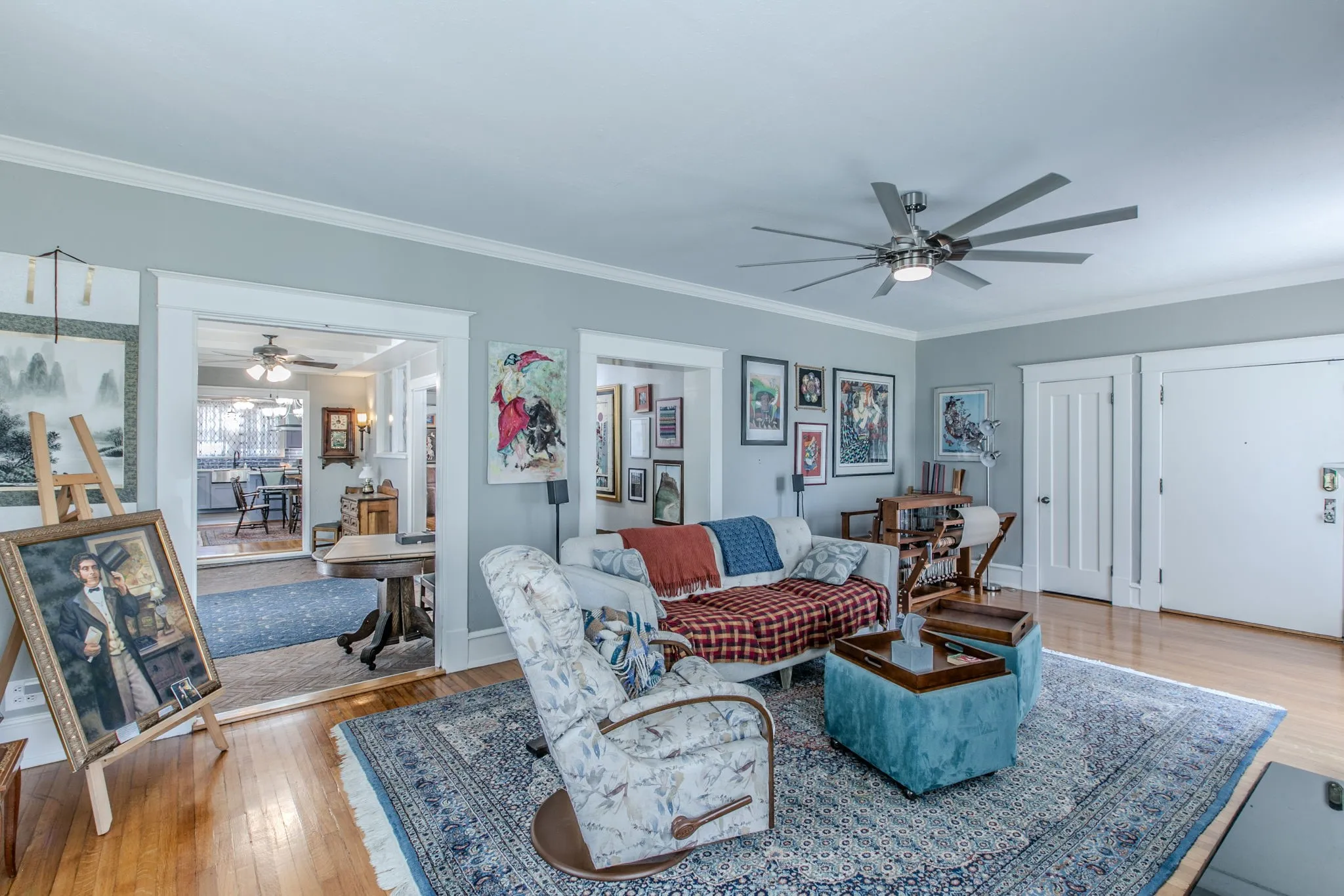 Hardwood flooring, crown molding, a modern ceiling fan, and white trim throughout