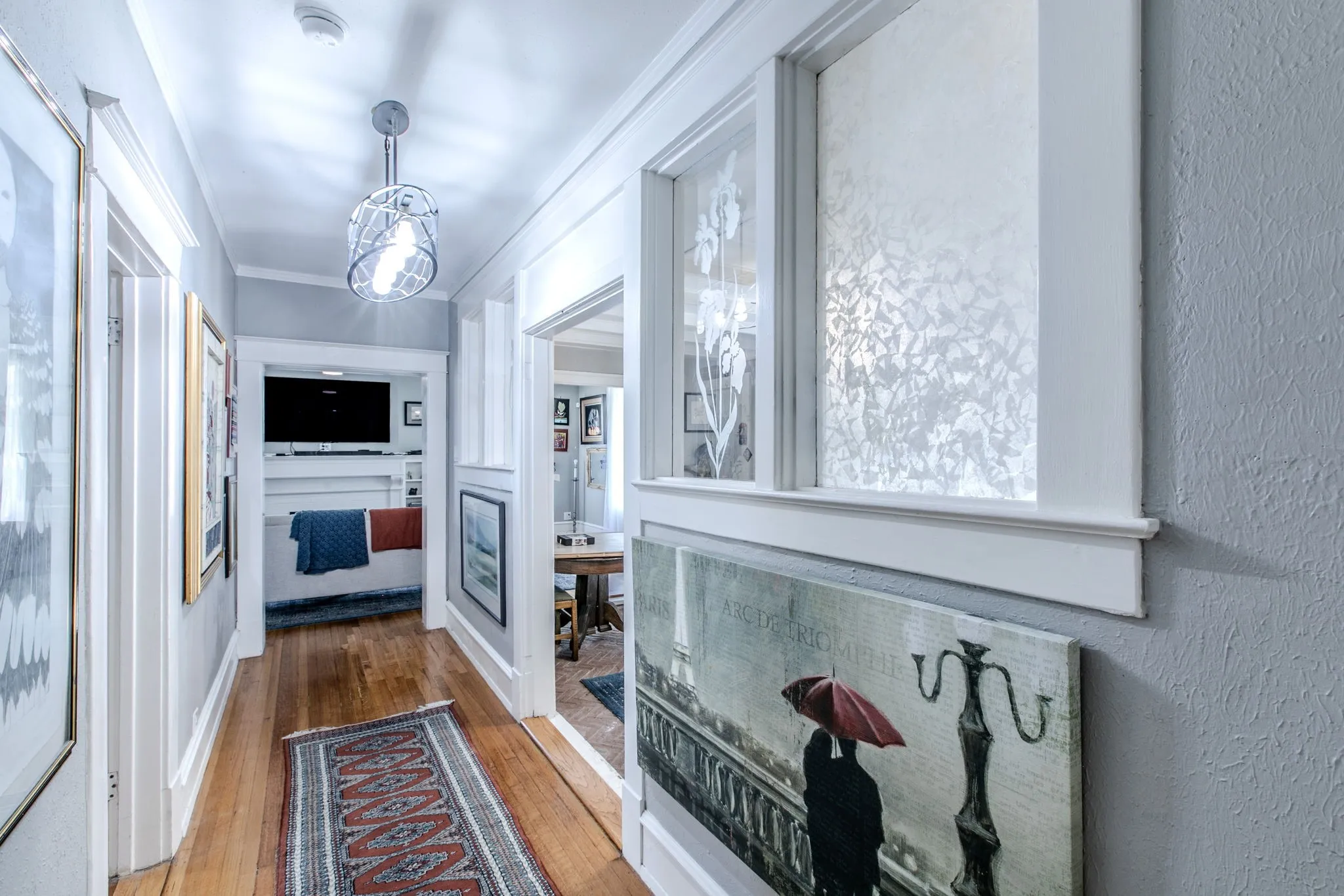 Hardwood flooring, painted walls, detailed trim work, and a contemporary ceiling fixture