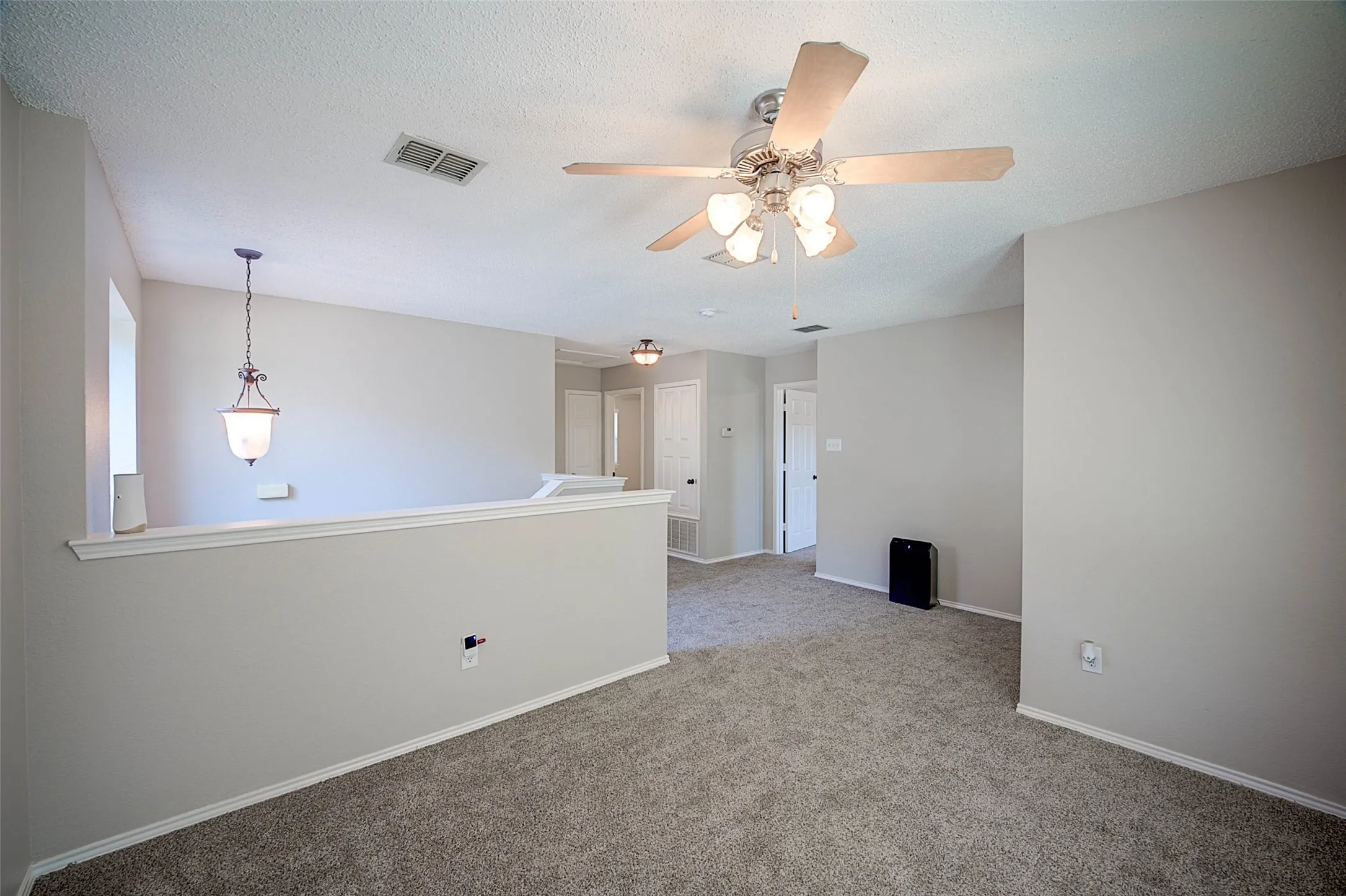 Carpeted flooring, neutral wall paint, ceiling fan with integrated lighting, recessed lighting, and a hanging pendant light fixture