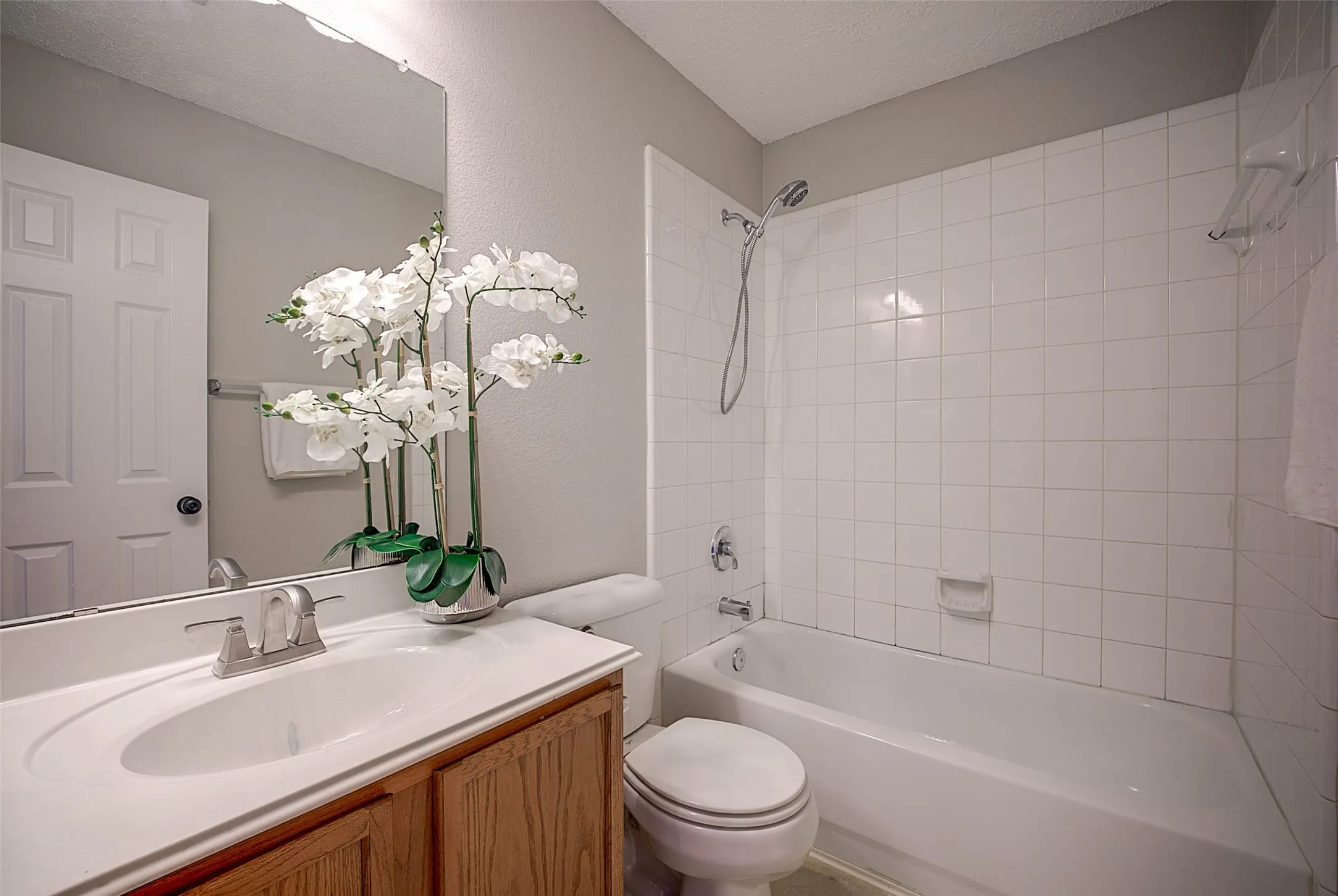 Vanity with integrated sink, wood-finish cabinetry, and brushed nickel faucet