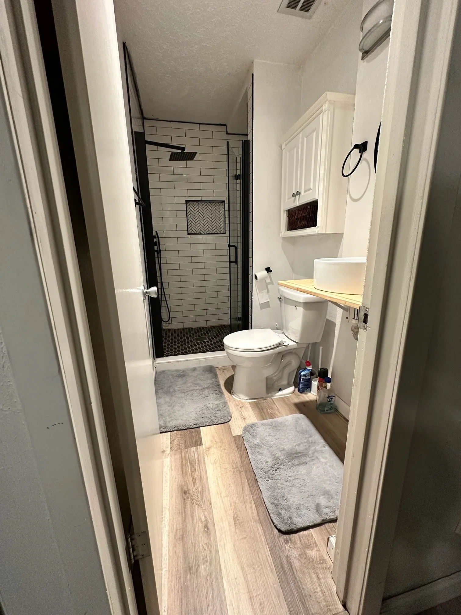 Walk-in shower with subway tile surround and black-framed glass enclosure