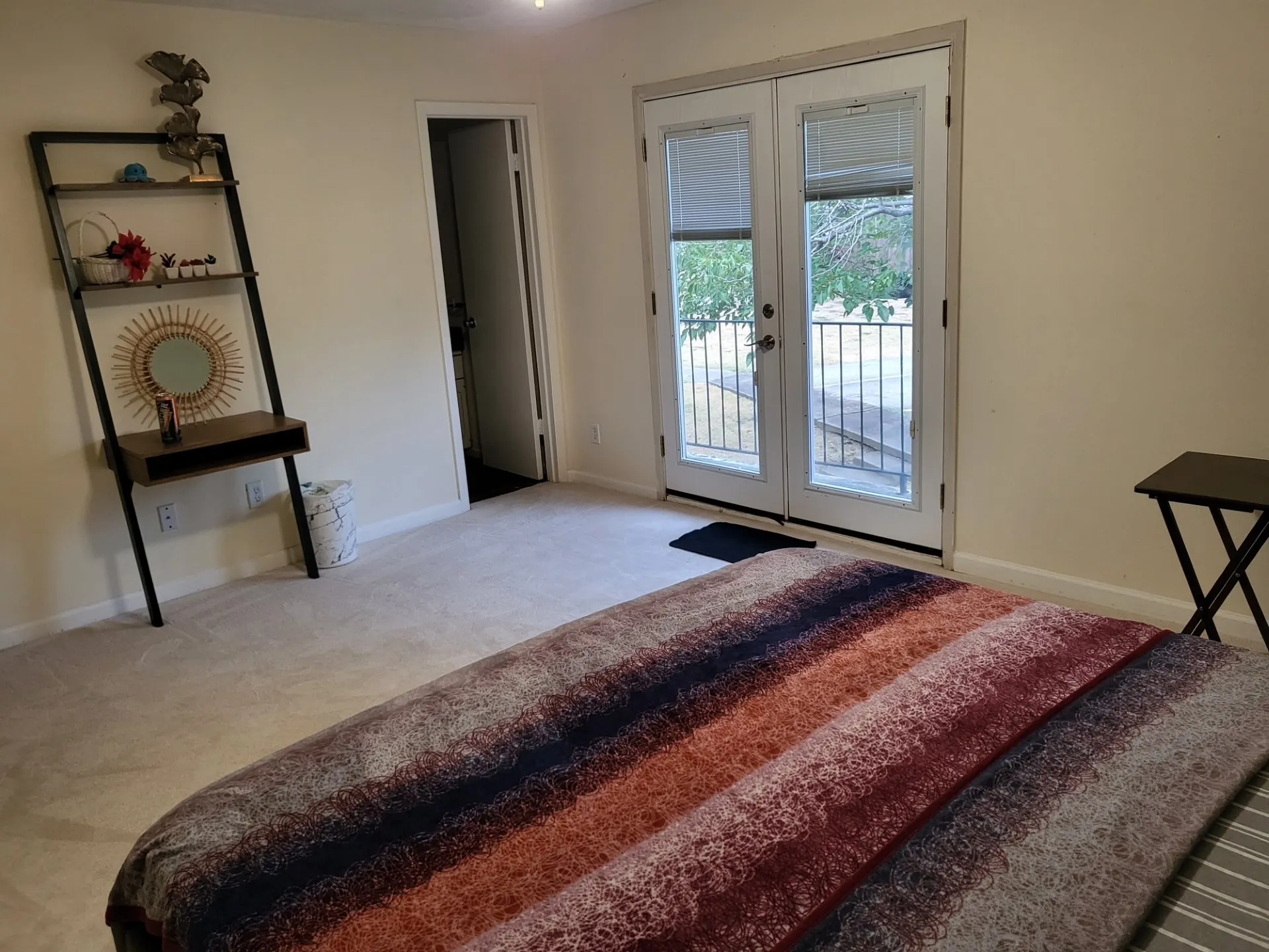 Double French doors, light-toned carpeting, and a white interior door