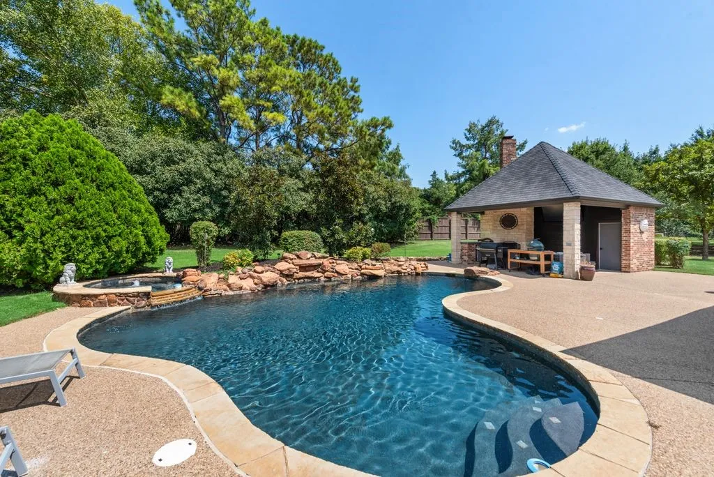 Freeform swimming pool with integrated spa and rock water feature