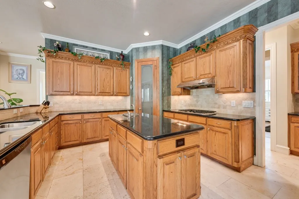 Corner pantry, island with wash sink and gas cooktop.