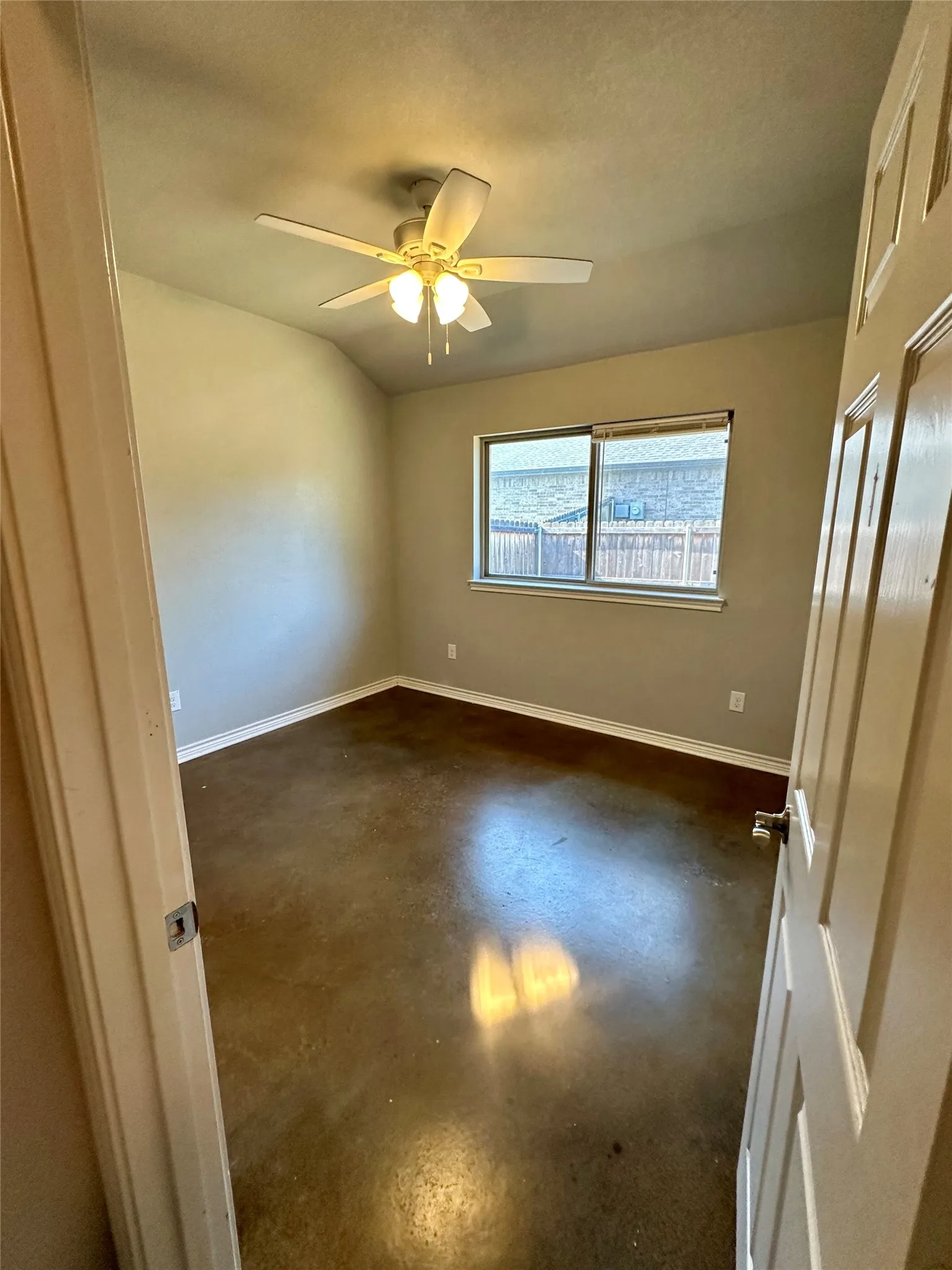 Featuring concrete flooring, a ceiling fan, and baseboards